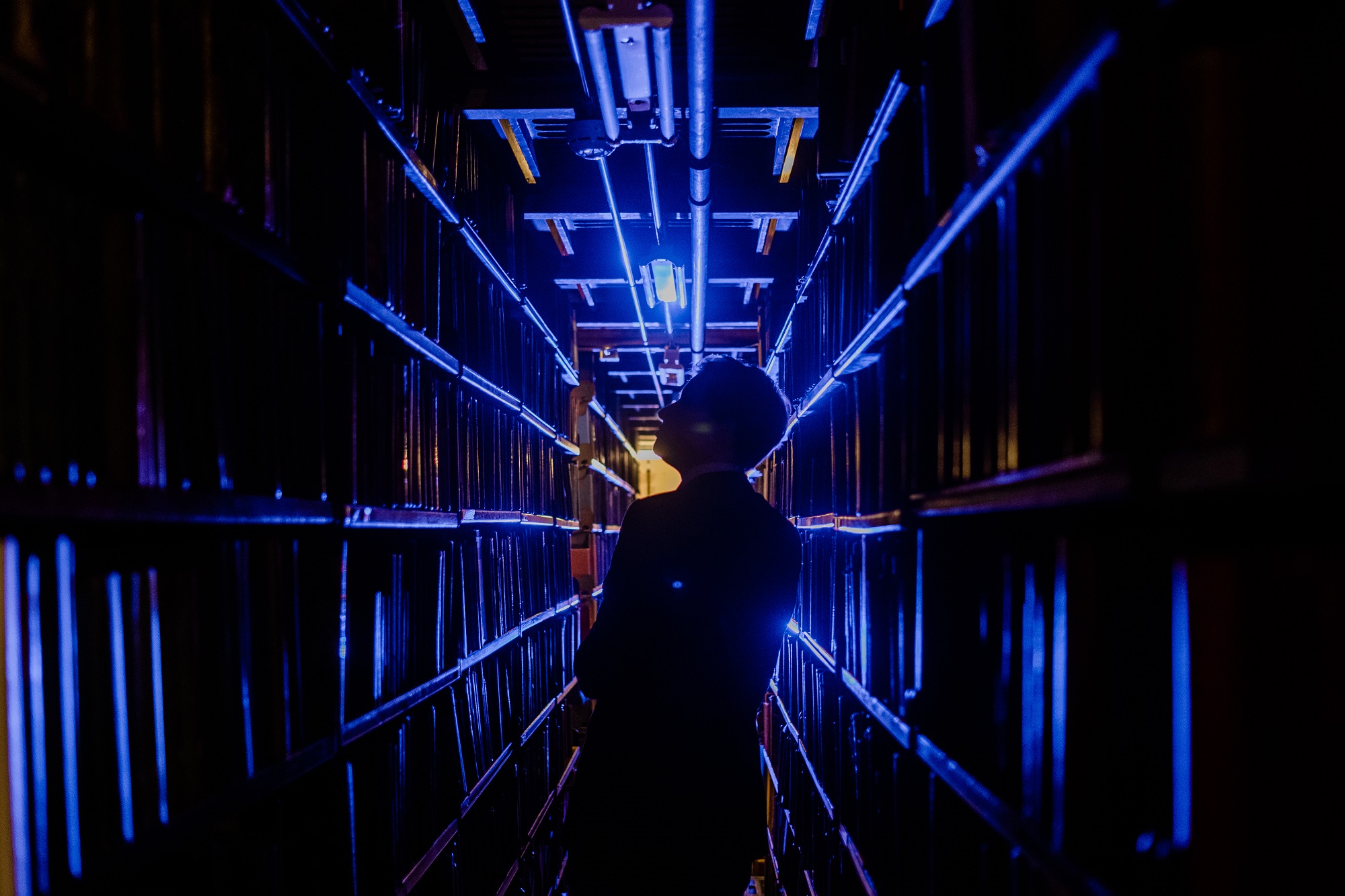 Illuminated blue corridor in The London Library, ideal for unique networking events.