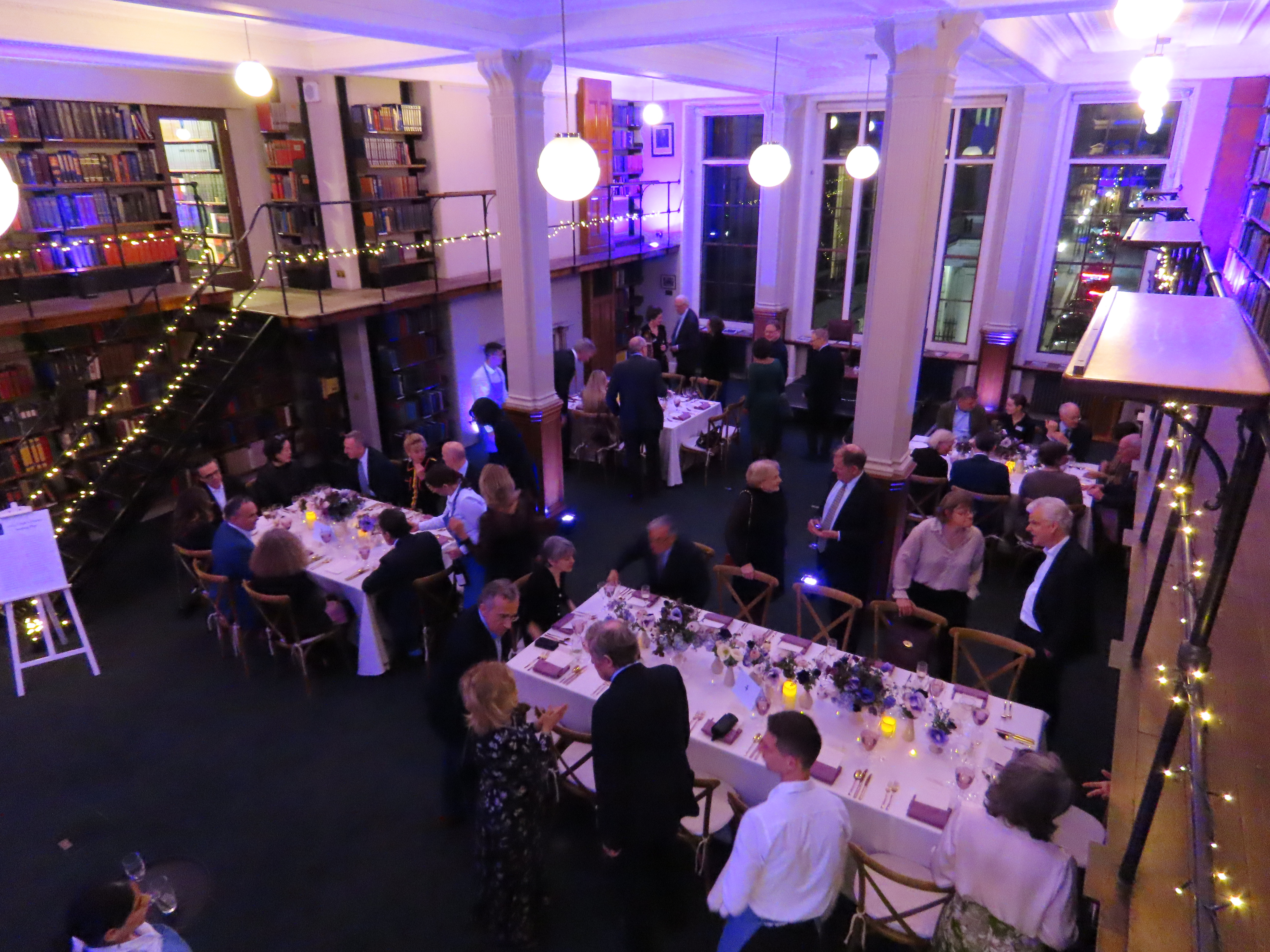 Elegant dinner event in The London Library with soft lighting and charming book backdrop.
