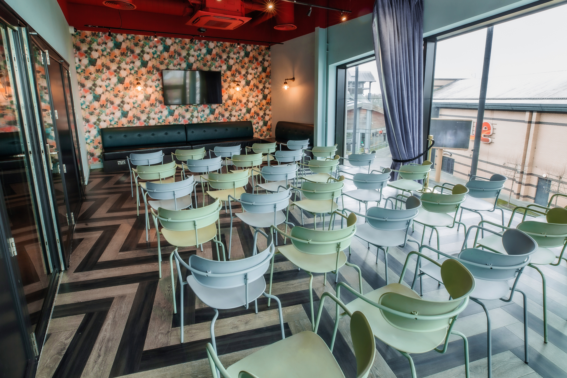 Modern event space with colorful chairs for presentations at Puttshack Lakeside.