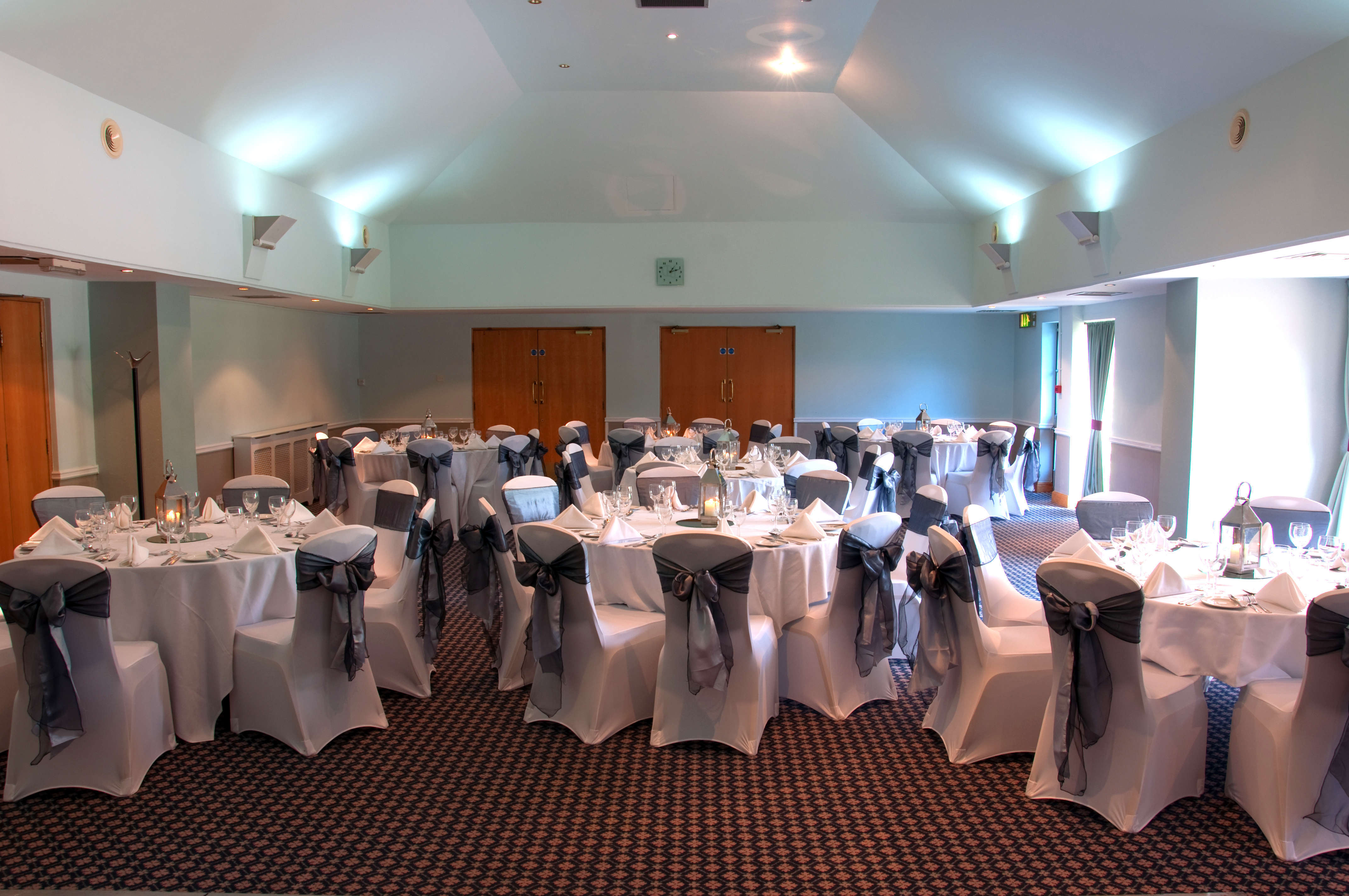 Hogarth Suite at Bridgewood Manor Hotel, elegant event space with round tables and gray sashes.