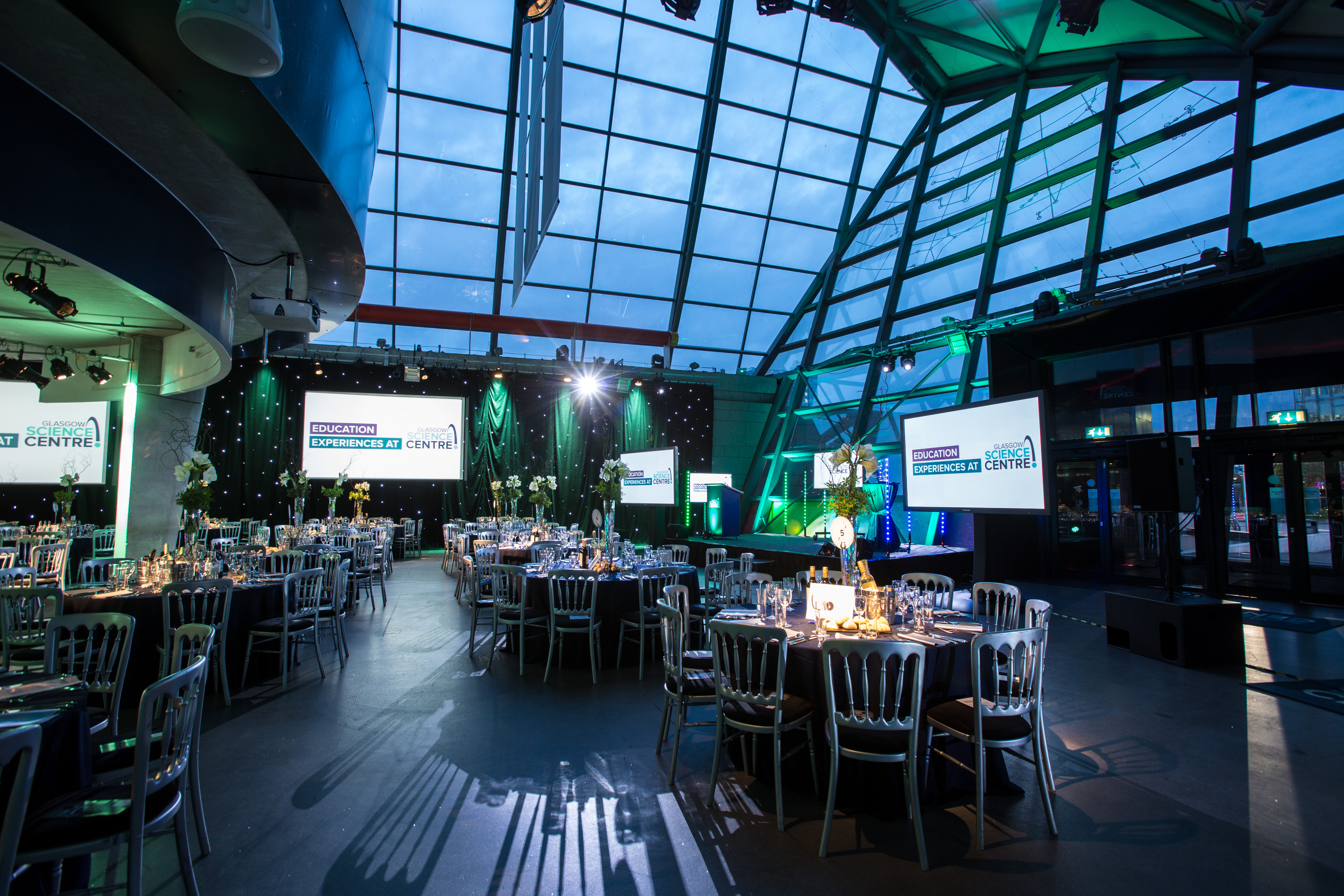 Atrium at Glasgow Science Centre: elegant event space with round tables, ideal for corporate galas.