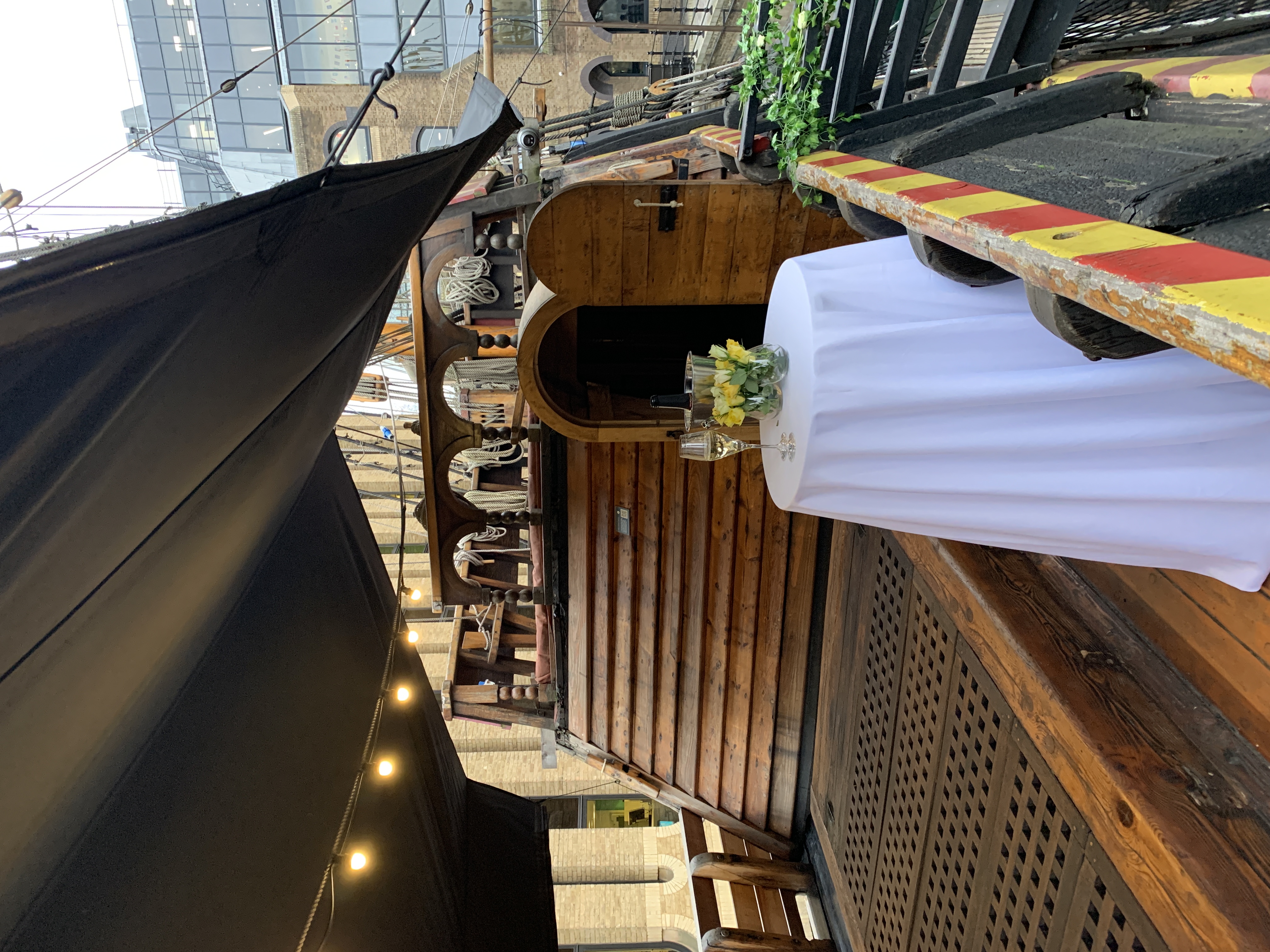 Whole Venue on The Golden Hinde, rustic ship event space with flowers and champagne.