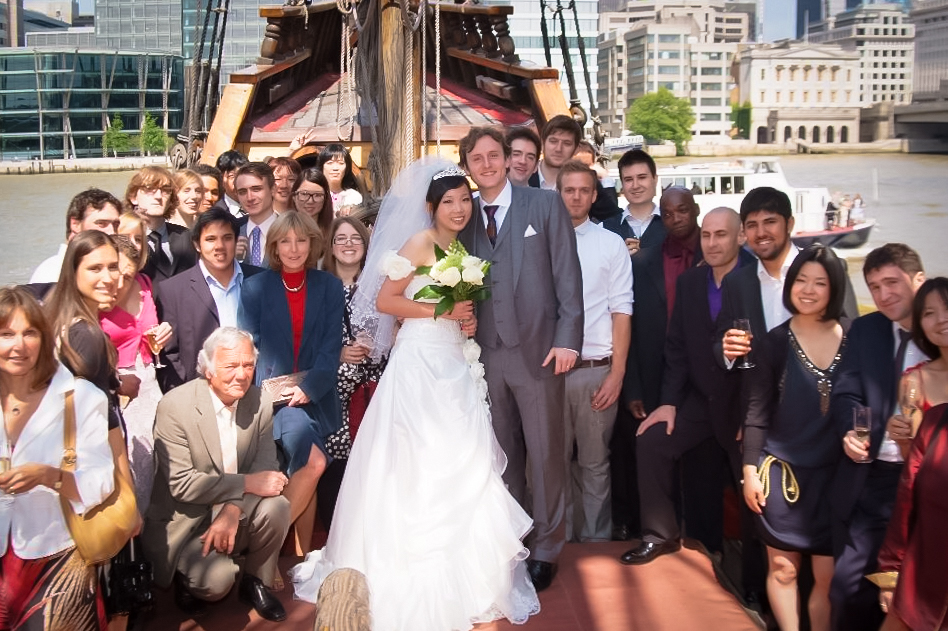Vibrant wedding celebration on The Golden Hinde with urban backdrop and joyful guests.