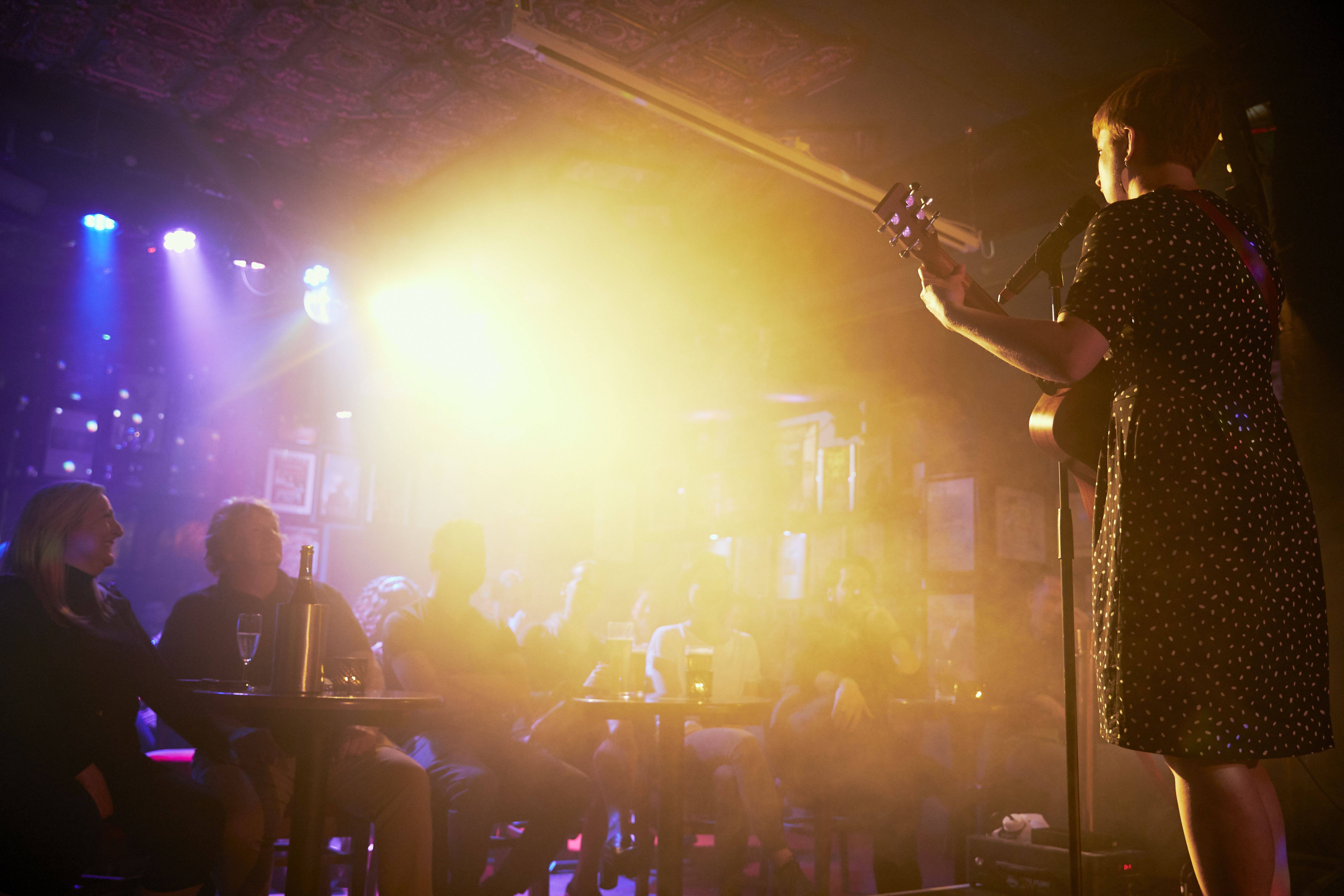 Intimate live performance at Phoenix Arts Club with warm lighting and engaged audience.