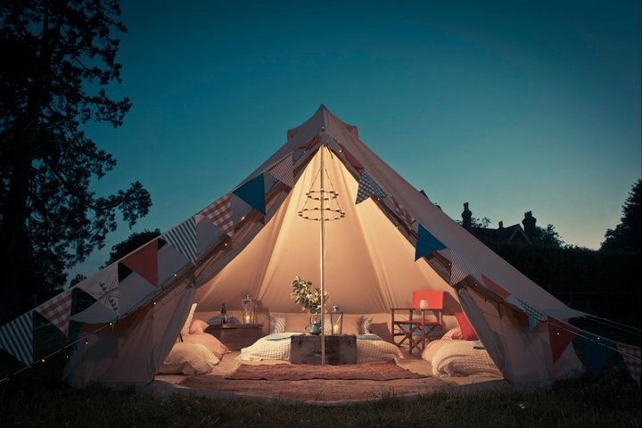 Cozy glamping tent with decor for unique outdoor events and retreats.