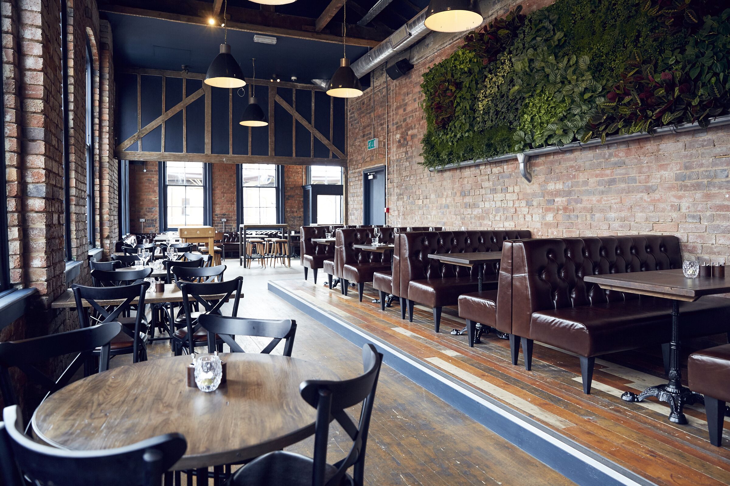Stylish venue with exposed brick and greenery, perfect for events and gatherings.