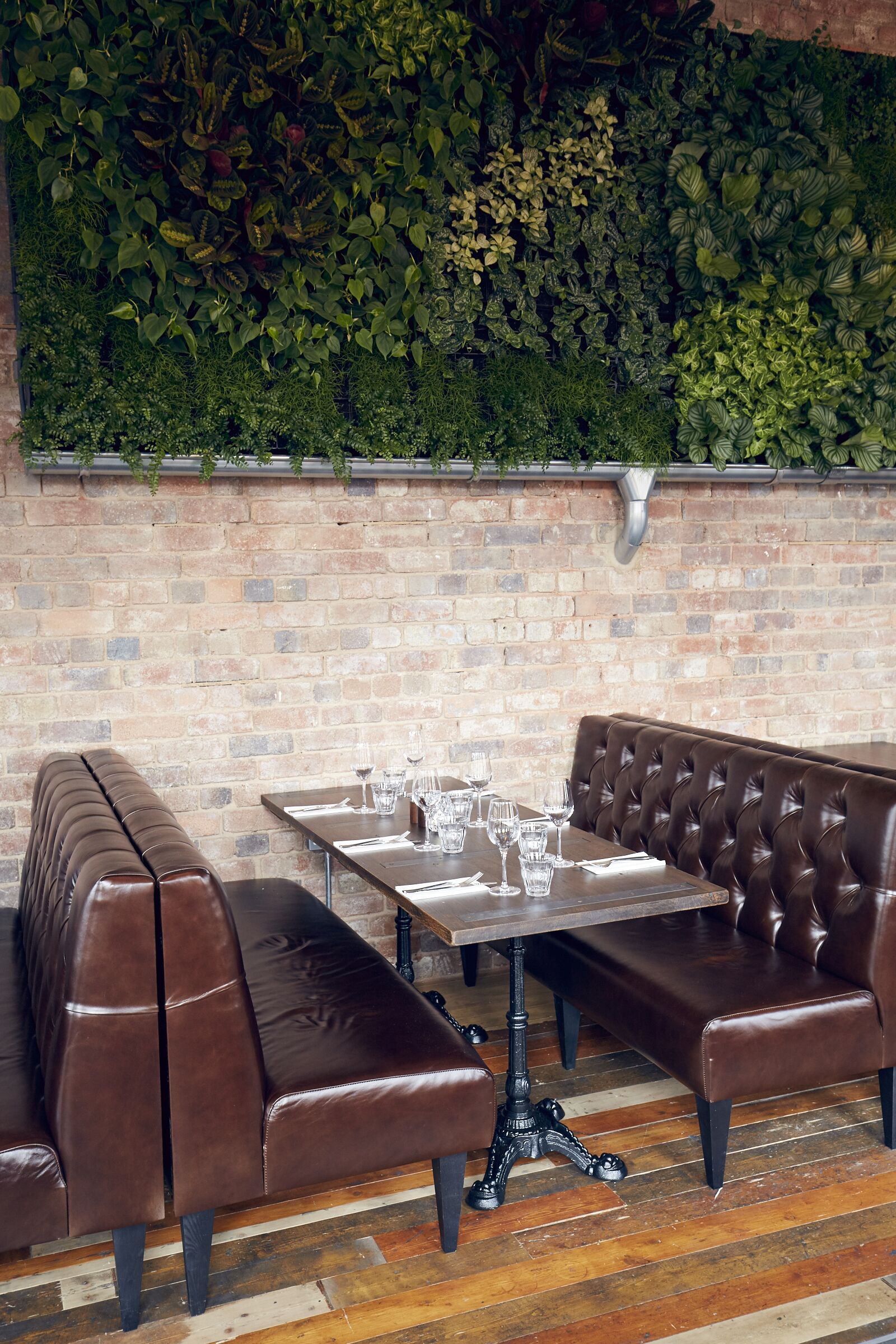 Stylish dining area with leather booth at The Live Wall, ideal for casual events and meetings.