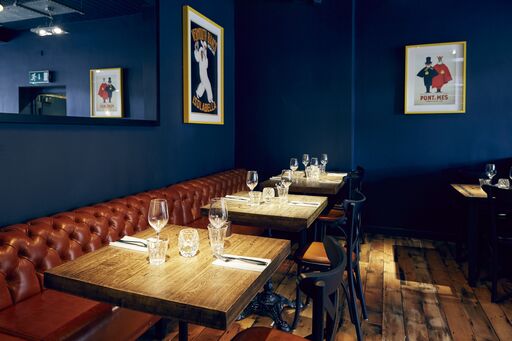 Stylish dining area with dark blue walls, perfect for intimate events and gatherings.