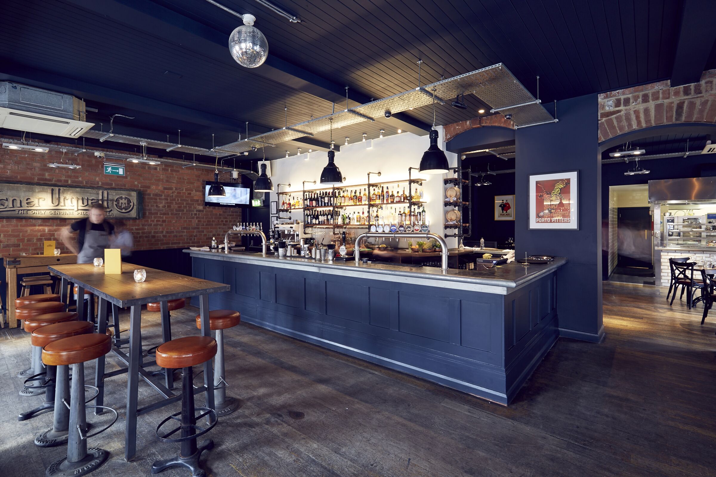 Stylish bar area with communal table at The Button Factory, perfect for networking events.