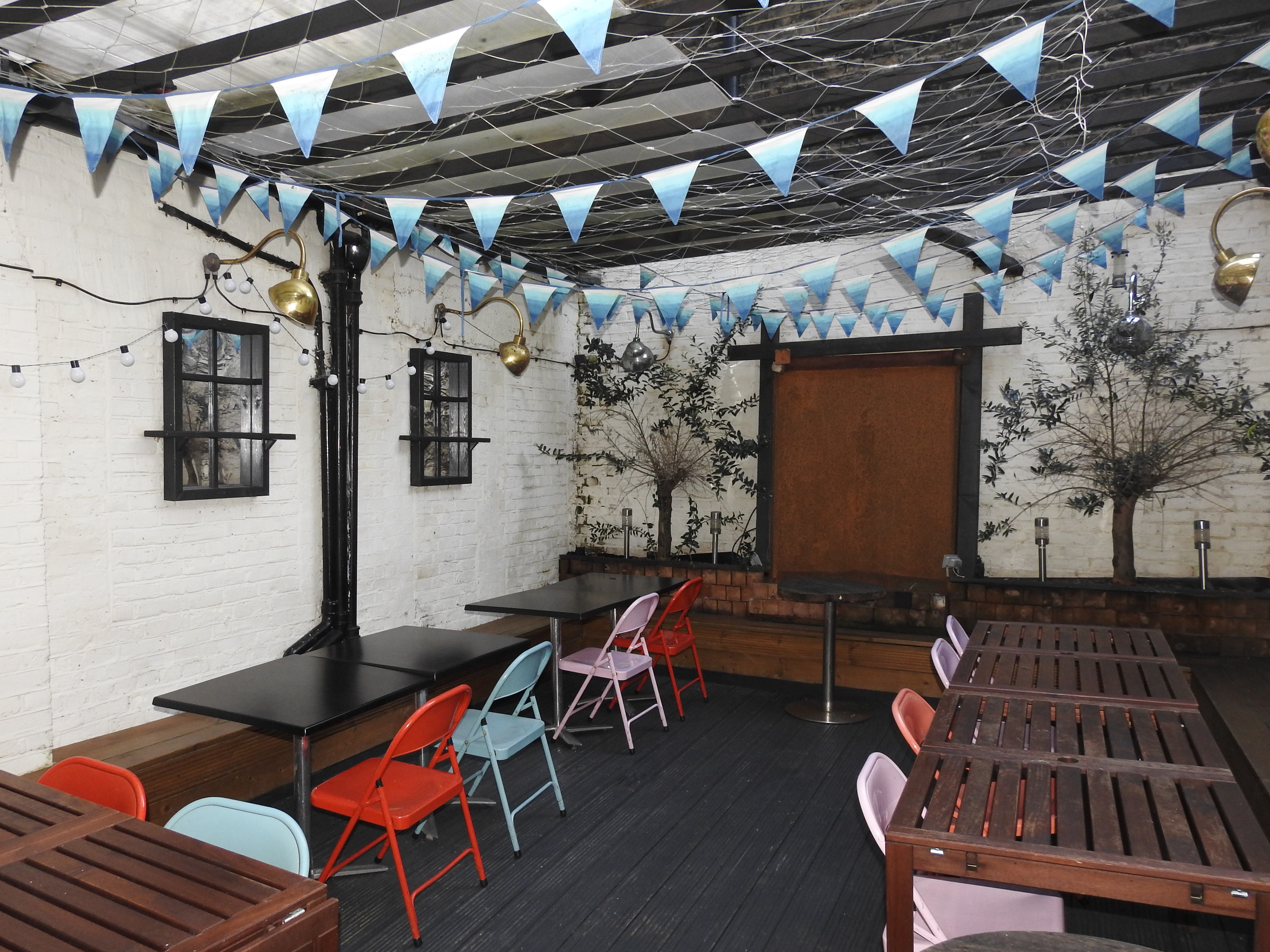 Versatile event space at The Chelsea Pensioner with colorful chairs for gatherings and workshops.