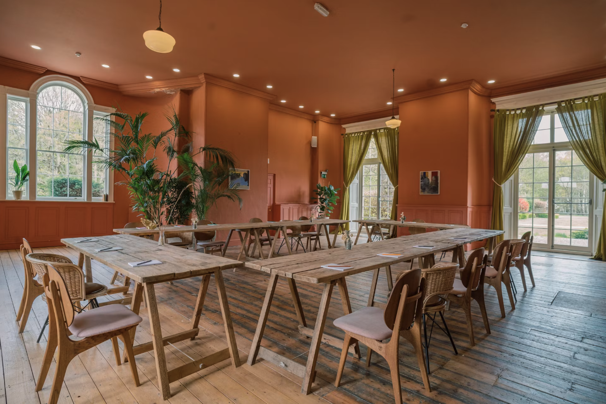Evelyn in a bright meeting space with U-shaped tables for collaborative brainstorming.