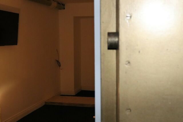 Minimalist meeting space with wall-mounted screen for corporate events and workshops.