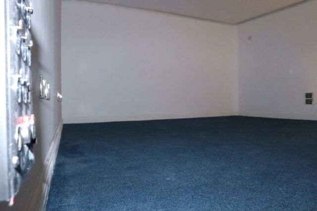 Empty event venue with blue carpet, perfect for intimate gatherings and meetings.