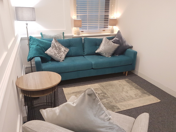 Cozy meeting space in The Bow Suite with plush teal sofa for brainstorming sessions.