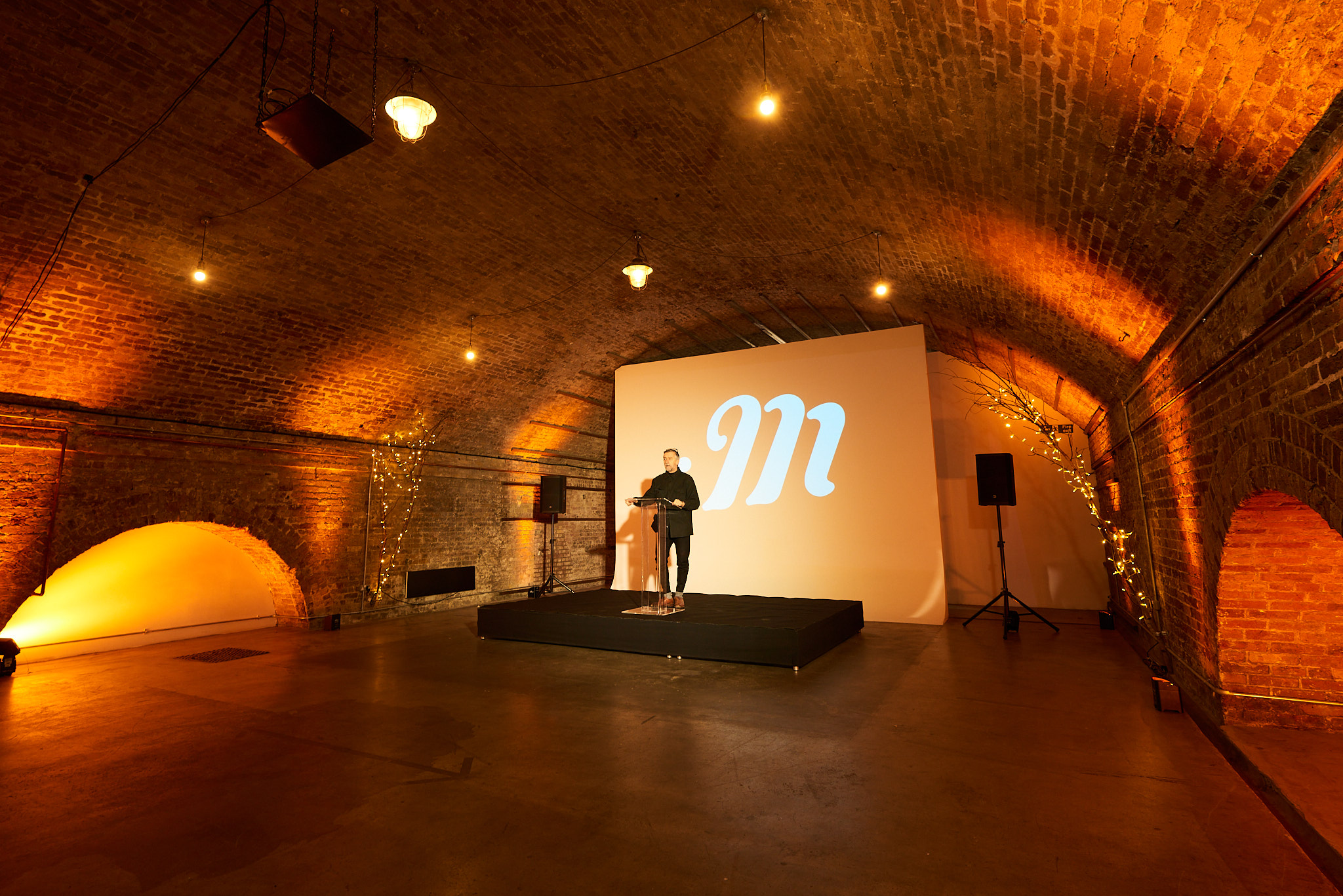 Stylish event space with speaker on stage, ideal for networking and presentations.