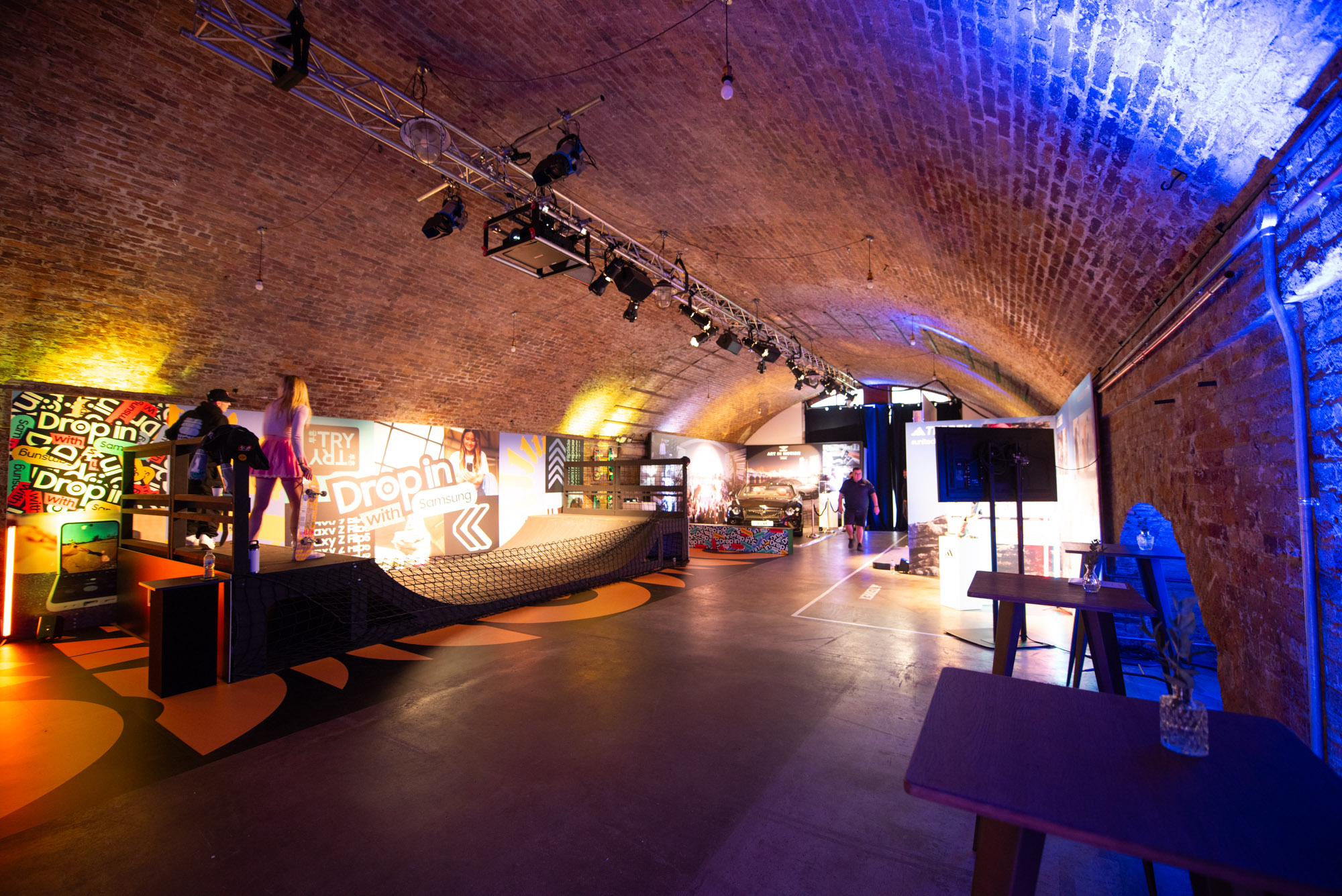 Dynamic event space with arched brick ceiling for networking and product launches.