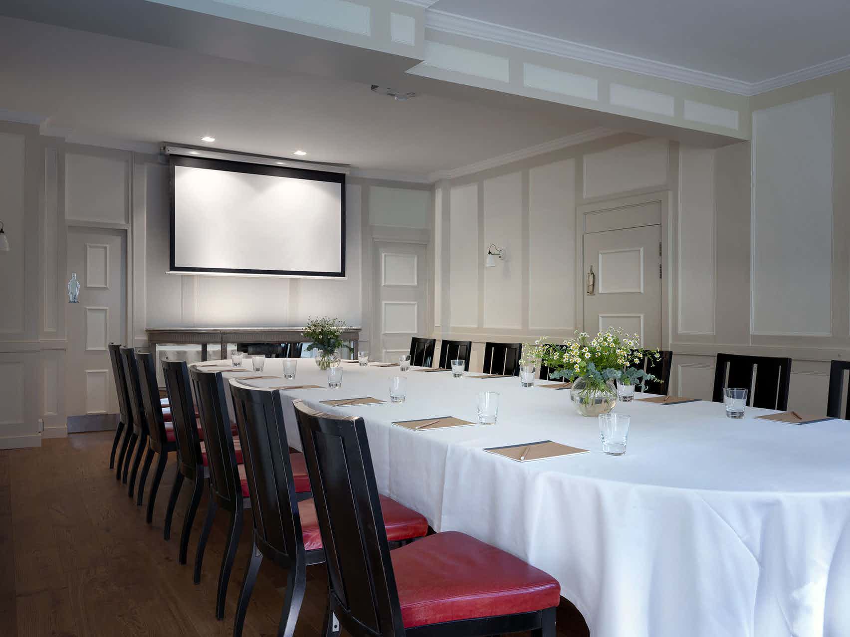 Elegant meeting room with long table, ideal for corporate events and workshops.