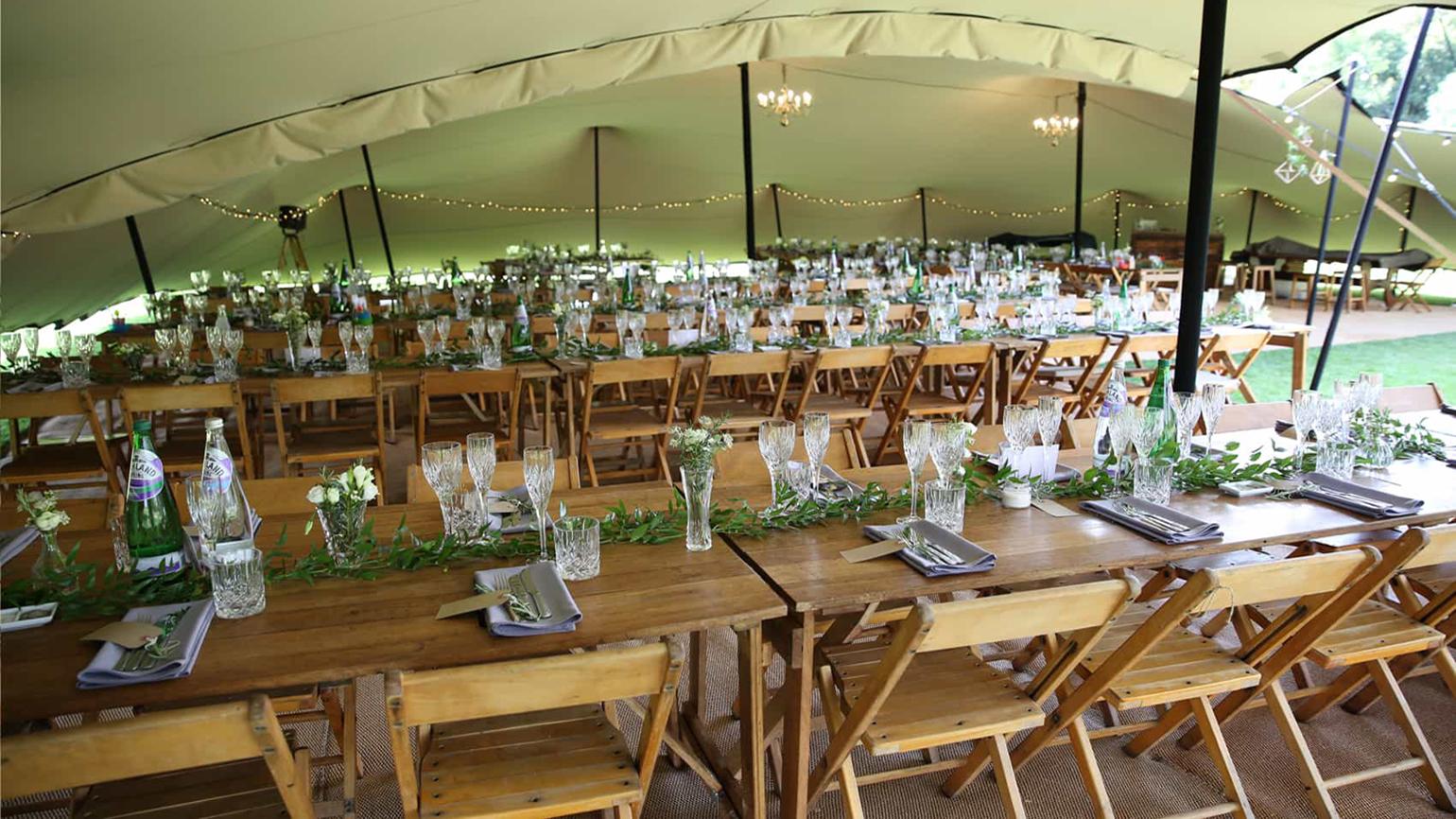 Elegant croquet lawn event space with wooden tables, perfect for weddings and gatherings.