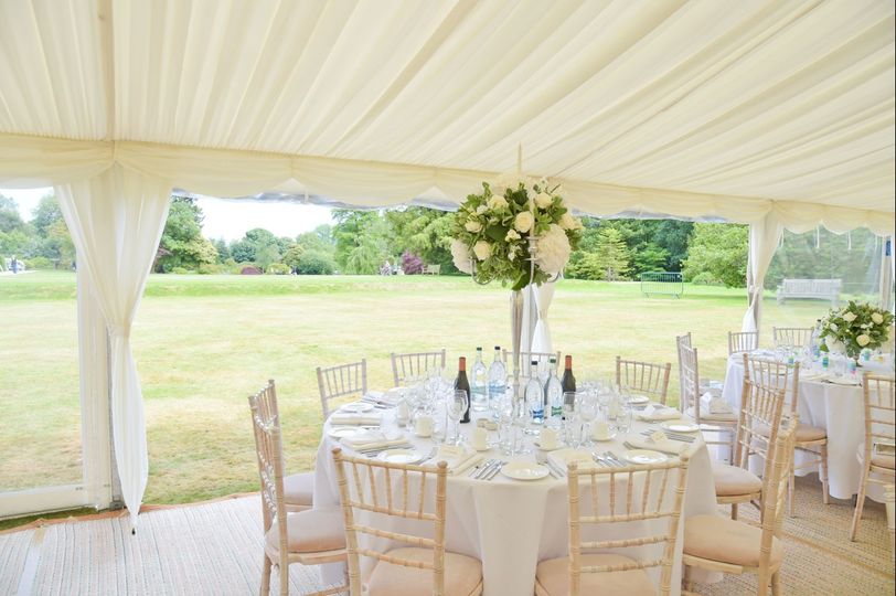 Elegant dining setup in marquee at Wakehurst Croquet Lawn for weddings and events.