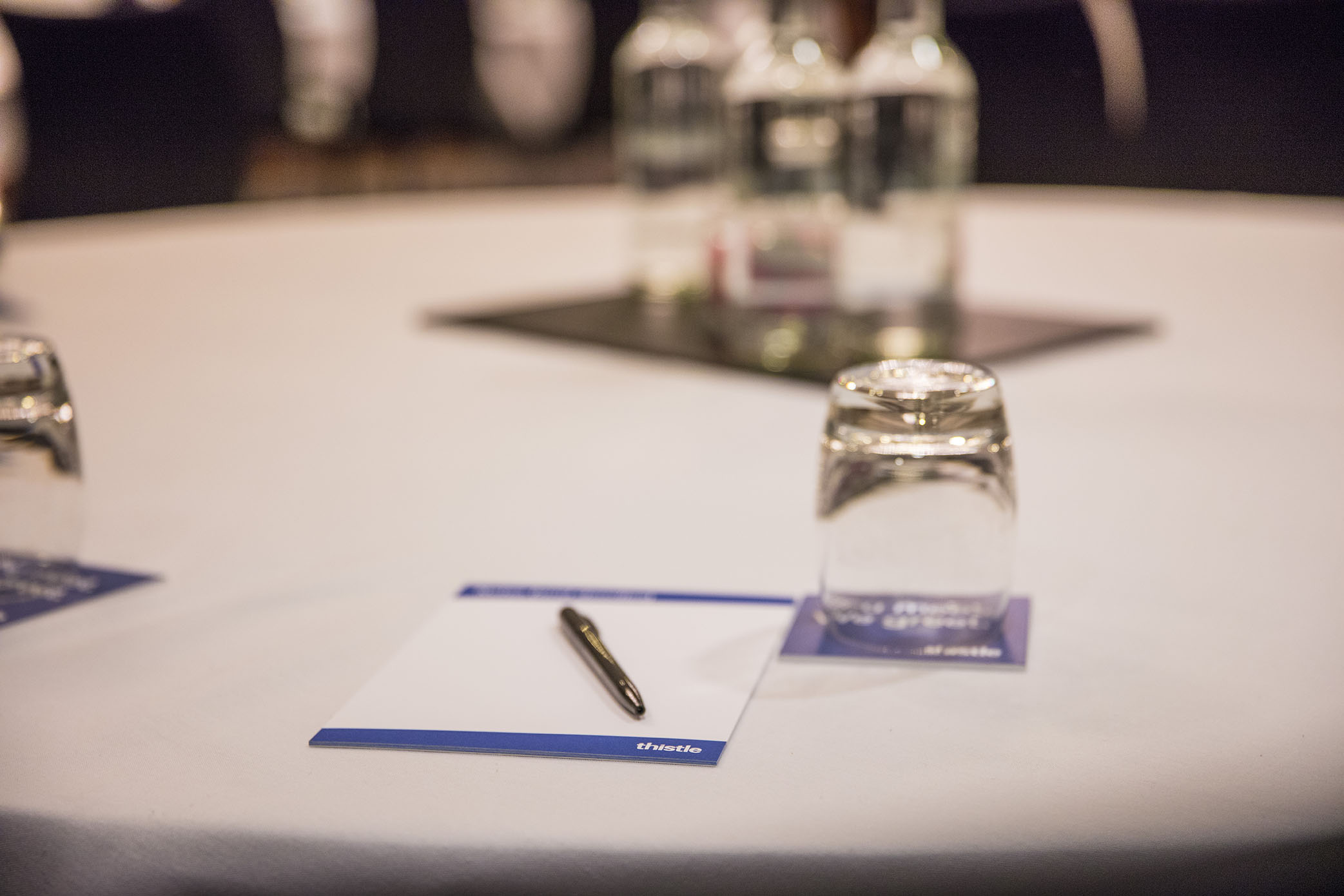 Meeting setup at Hawksmoor Thistle Holborn with round table, water bottles, and notepads.