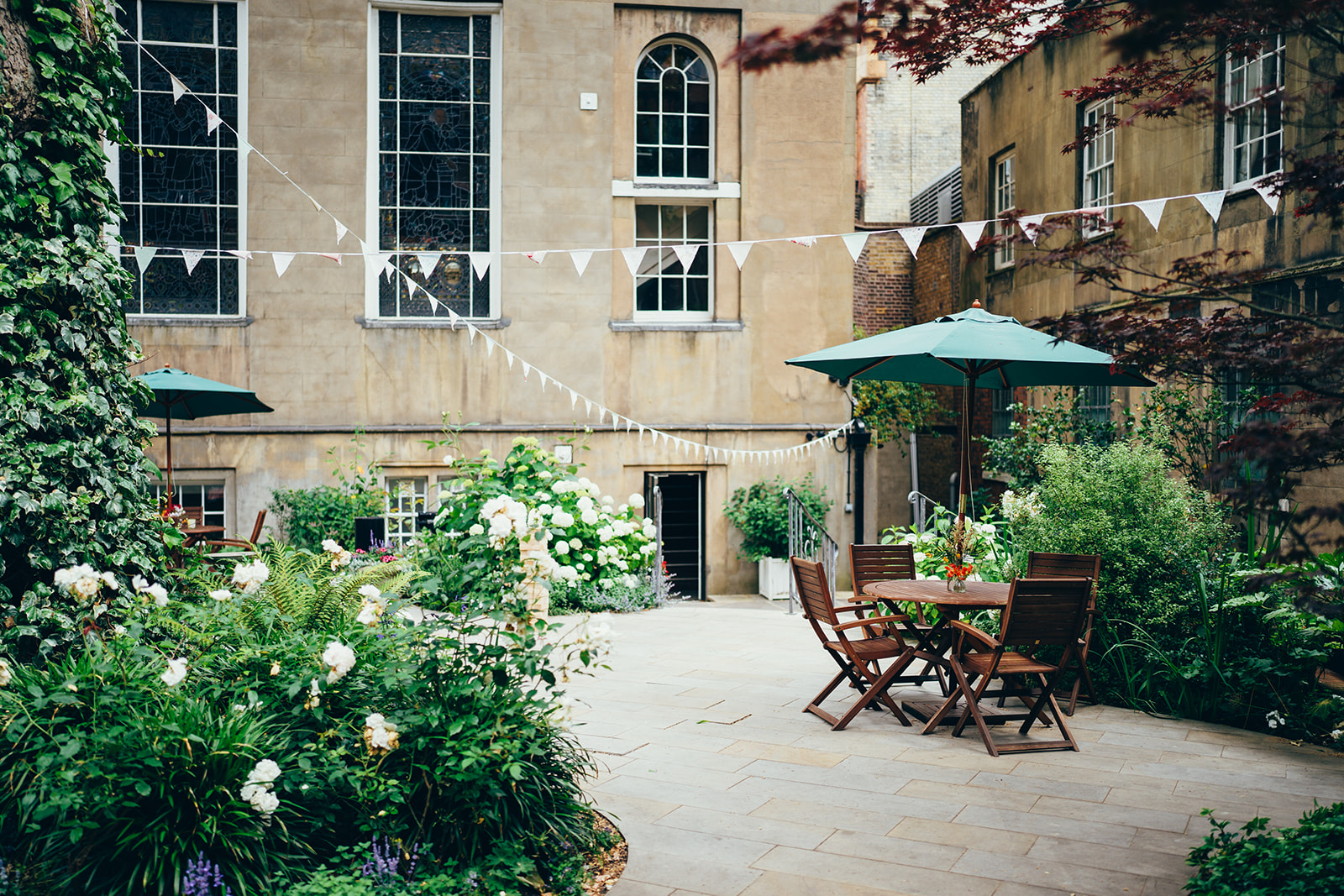 Summer party venue at Stationers' Hall with lush greenery and festive bunting.