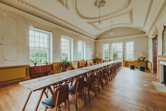 Spacious meeting room with wooden table, ideal for workshops and collaborative sessions.