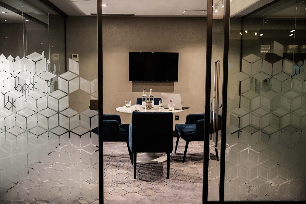 Modern meeting room in Malmaison Birmingham with glass walls, ideal for team meetings.