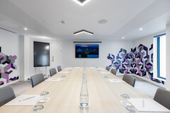 Modern meeting room in YOTEL Edinburgh with vibrant wall art for creative collaboration.