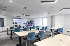 Modern meeting room in YOTEL Edinburgh with ergonomic chairs for corporate events.