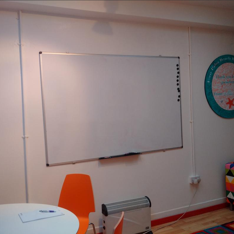 Meeting room with blank whiteboard for brainstorming and collaboration sessions.
