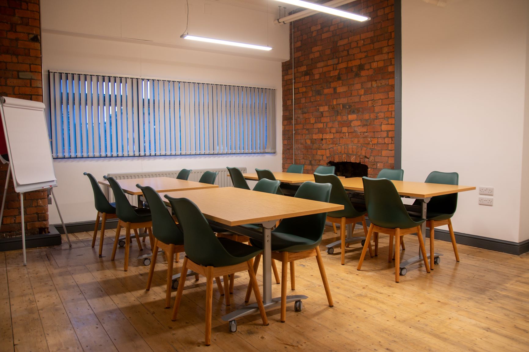 Versatile meeting space with wooden floors for workshops and brainstorming sessions.