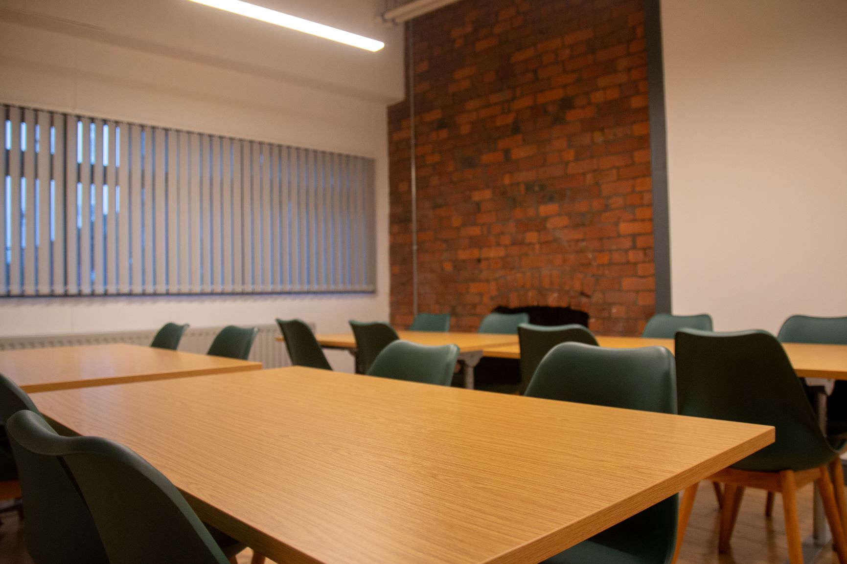 Versatile meeting space with wooden tables, ideal for workshops and collaborative sessions.