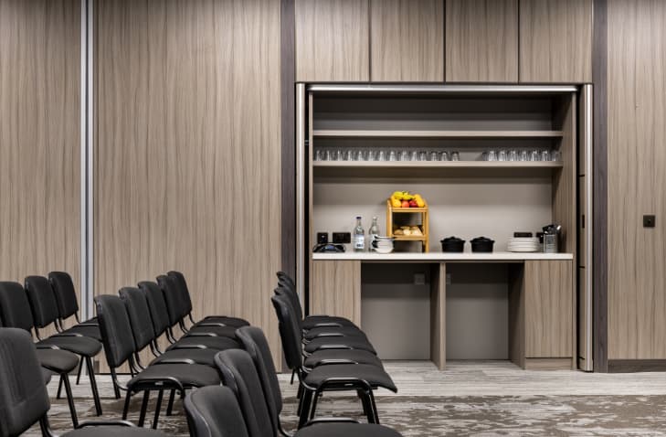 Breakout room with refreshment station at AC Marriott Manchester City Centre for corporate meetings.