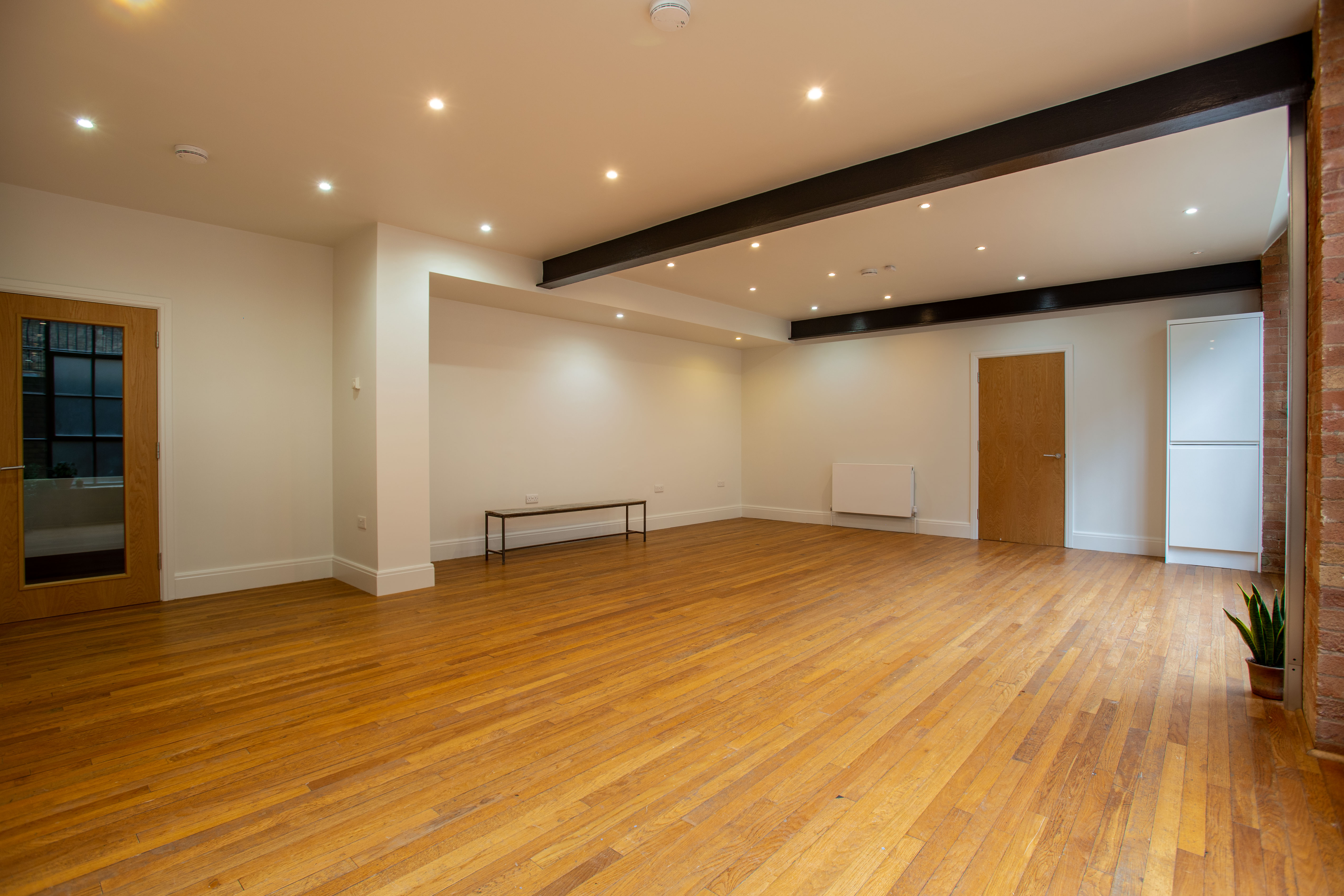 Versatile event space with polished wooden floors for workshops and gatherings.