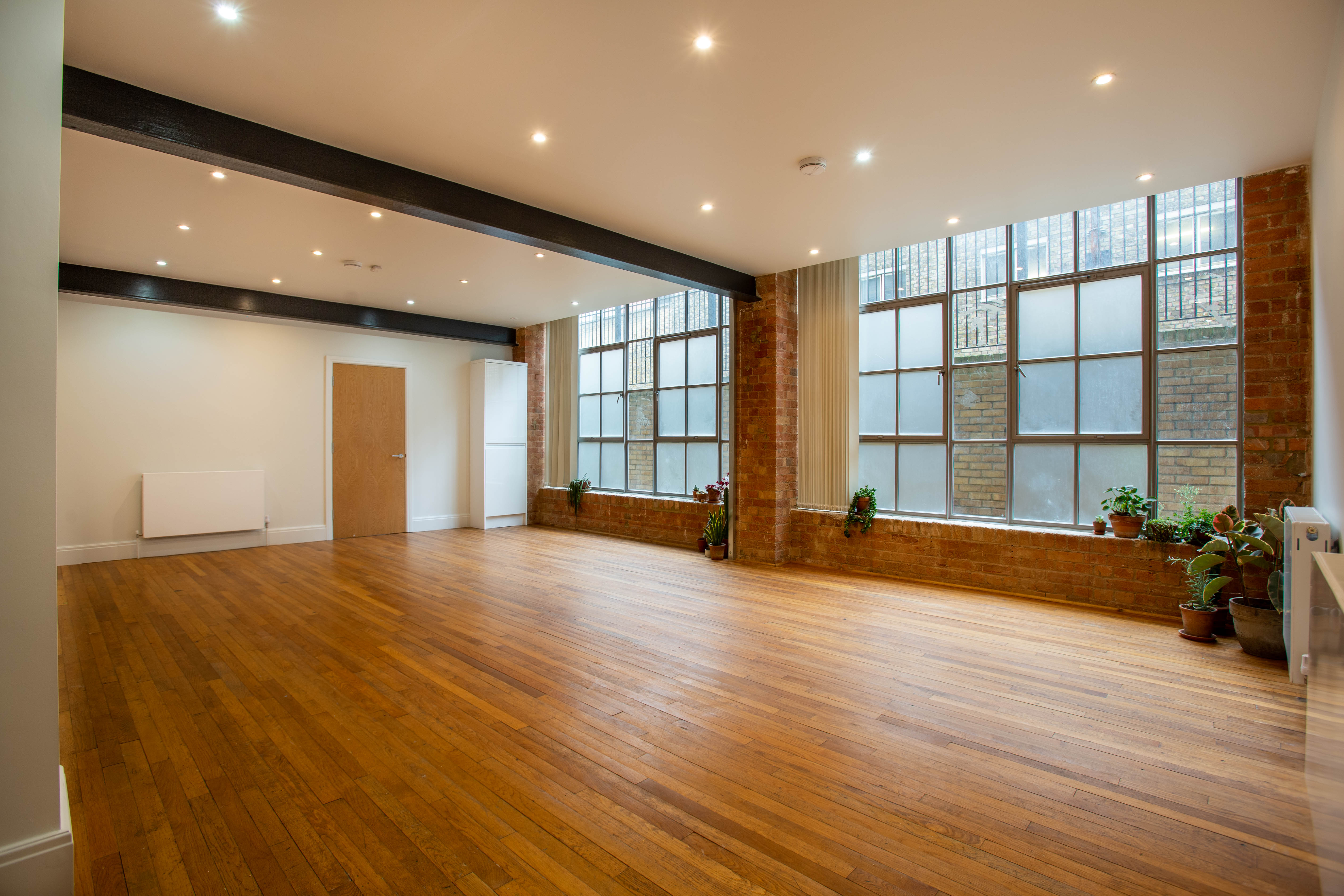 Spacious event space with large windows in The Warehouse, ideal for workshops and gatherings.