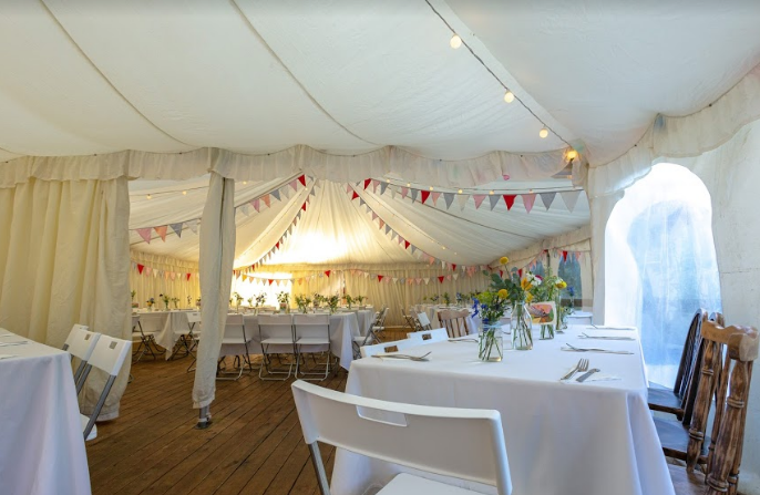Event tent at Beeses Riverside Bar with warm lighting for intimate gatherings.