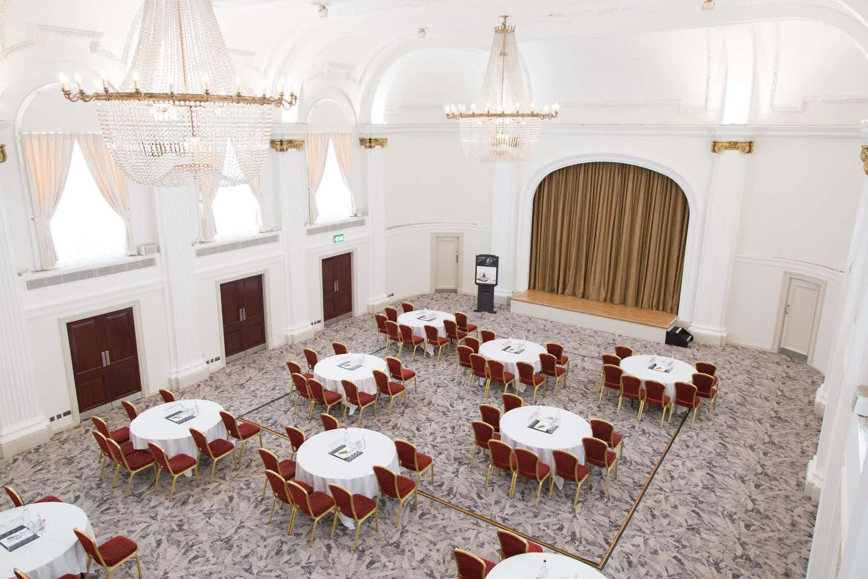 Spacious Mercure Grand Bristol ballroom set for meetings with elegant decor and natural light.