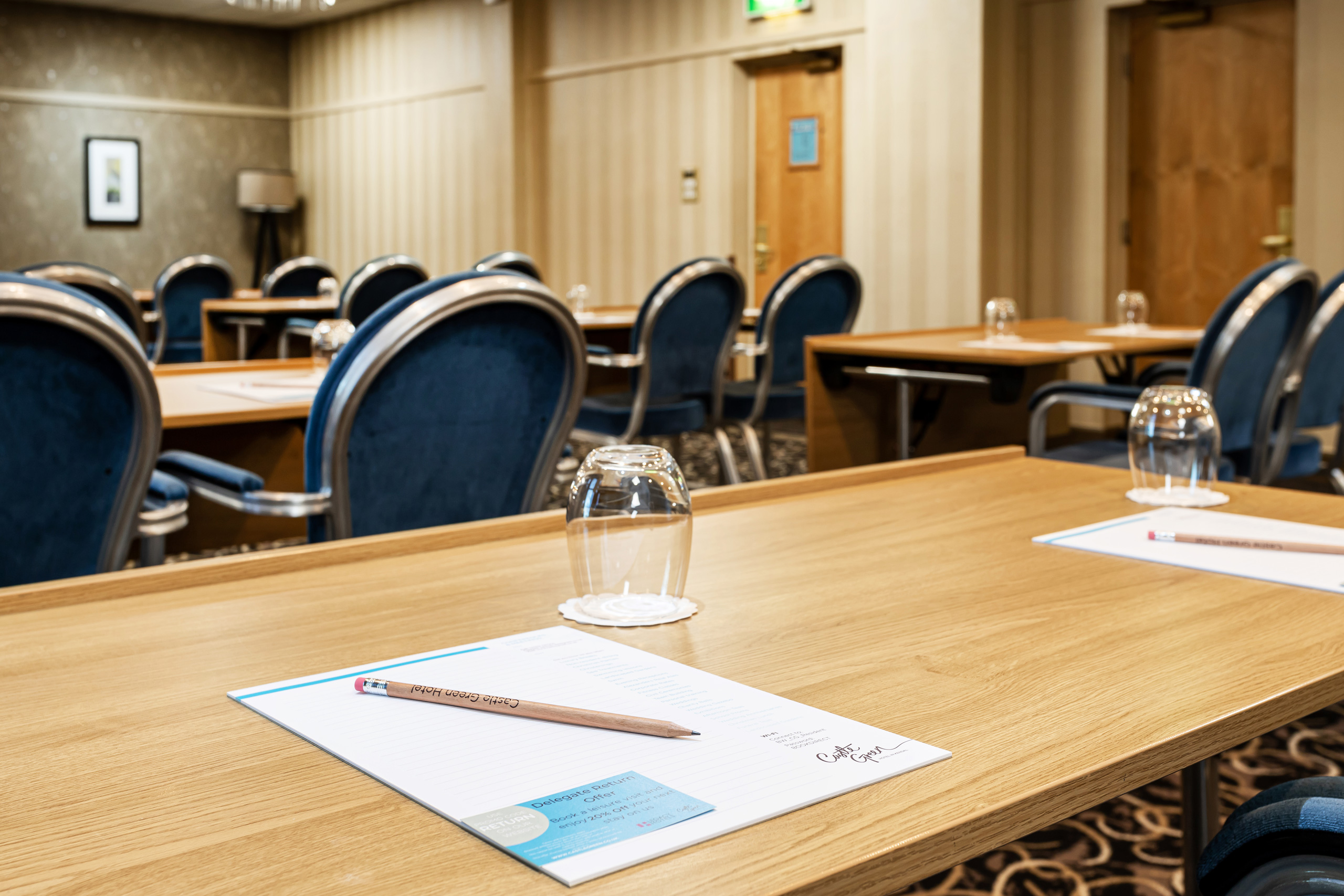 Oak Room at Castle Green Hotel, elegant meeting space with blue chairs for professional events.