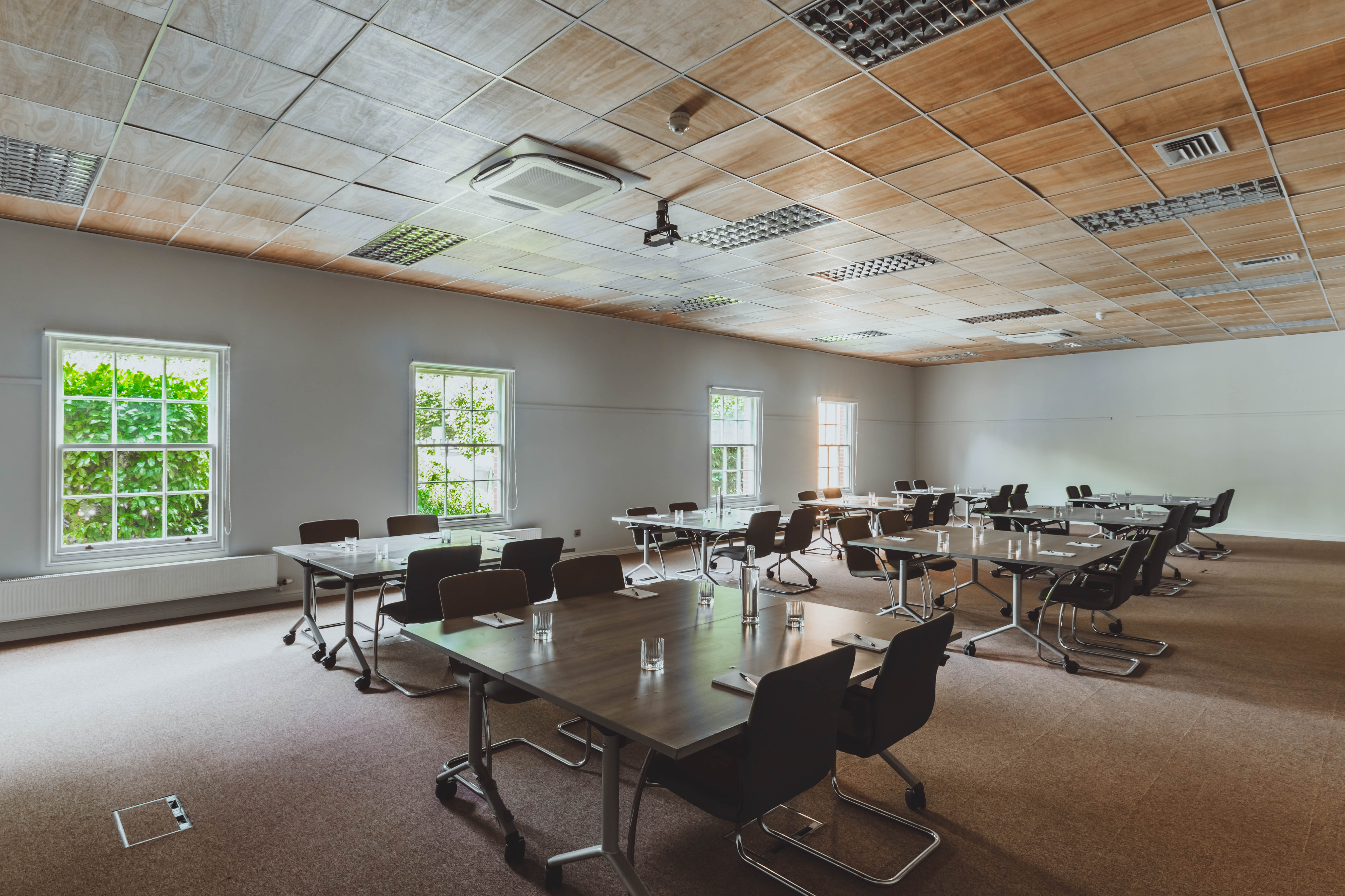 Versatile meeting space with natural light, ideal for workshops and corporate events.