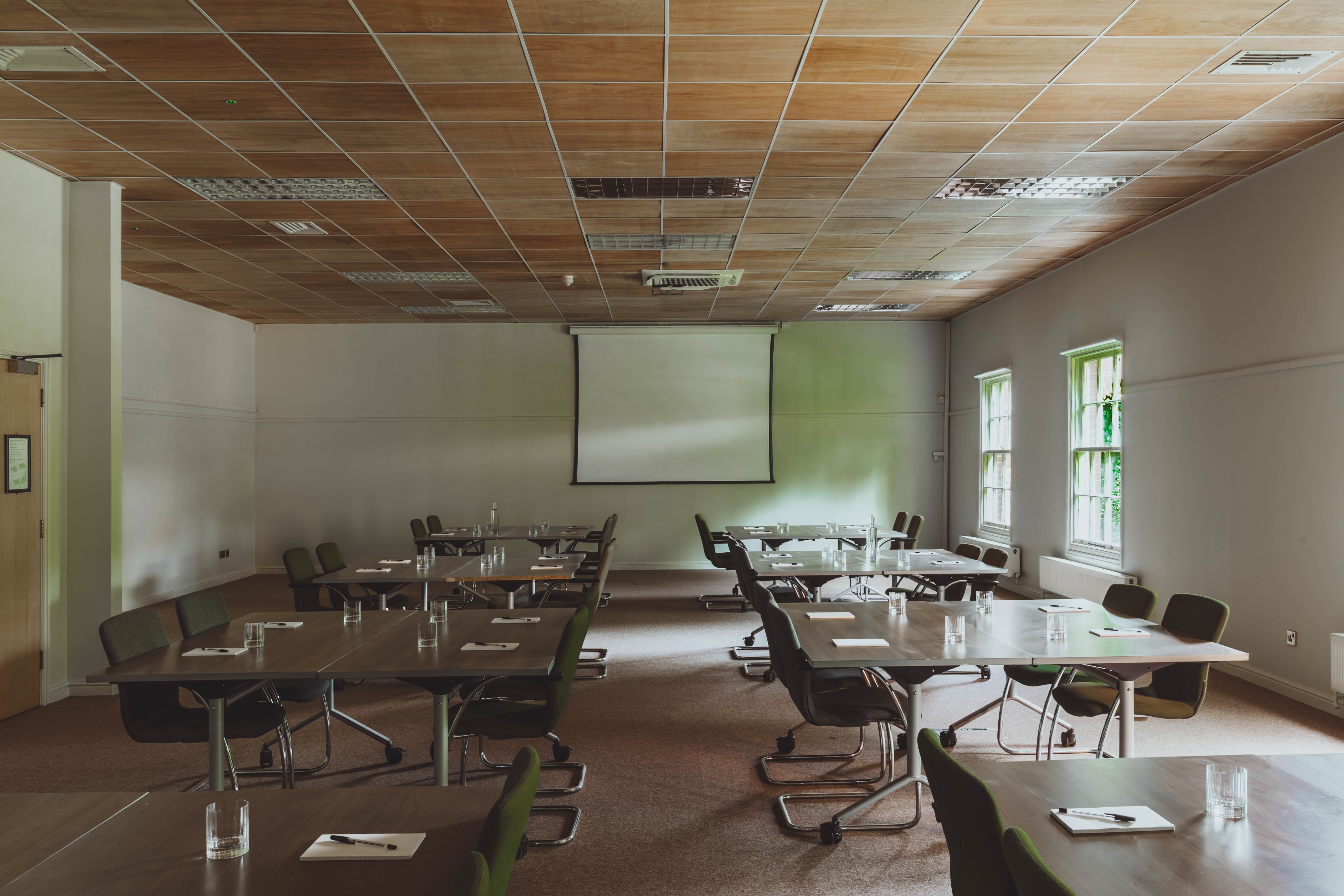 Versatile meeting room with tables for collaboration, ideal for workshops and team meetings.