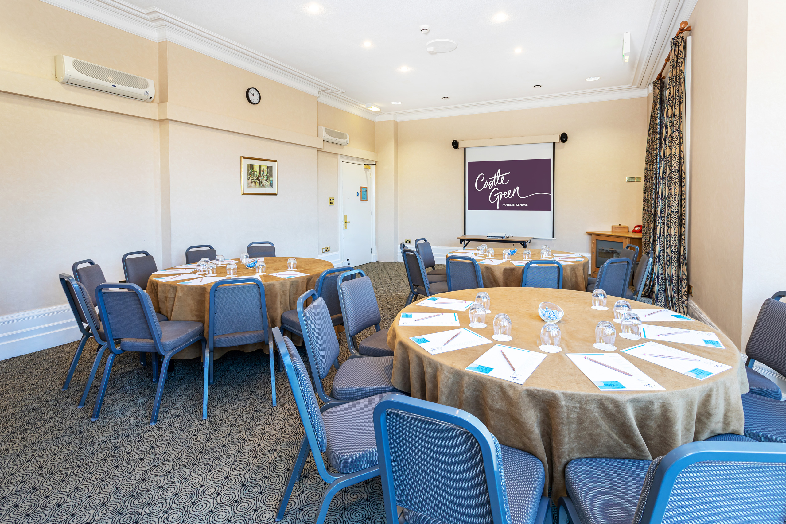 Garden Room at Castle Green Hotel, round tables set for corporate meetings and workshops.