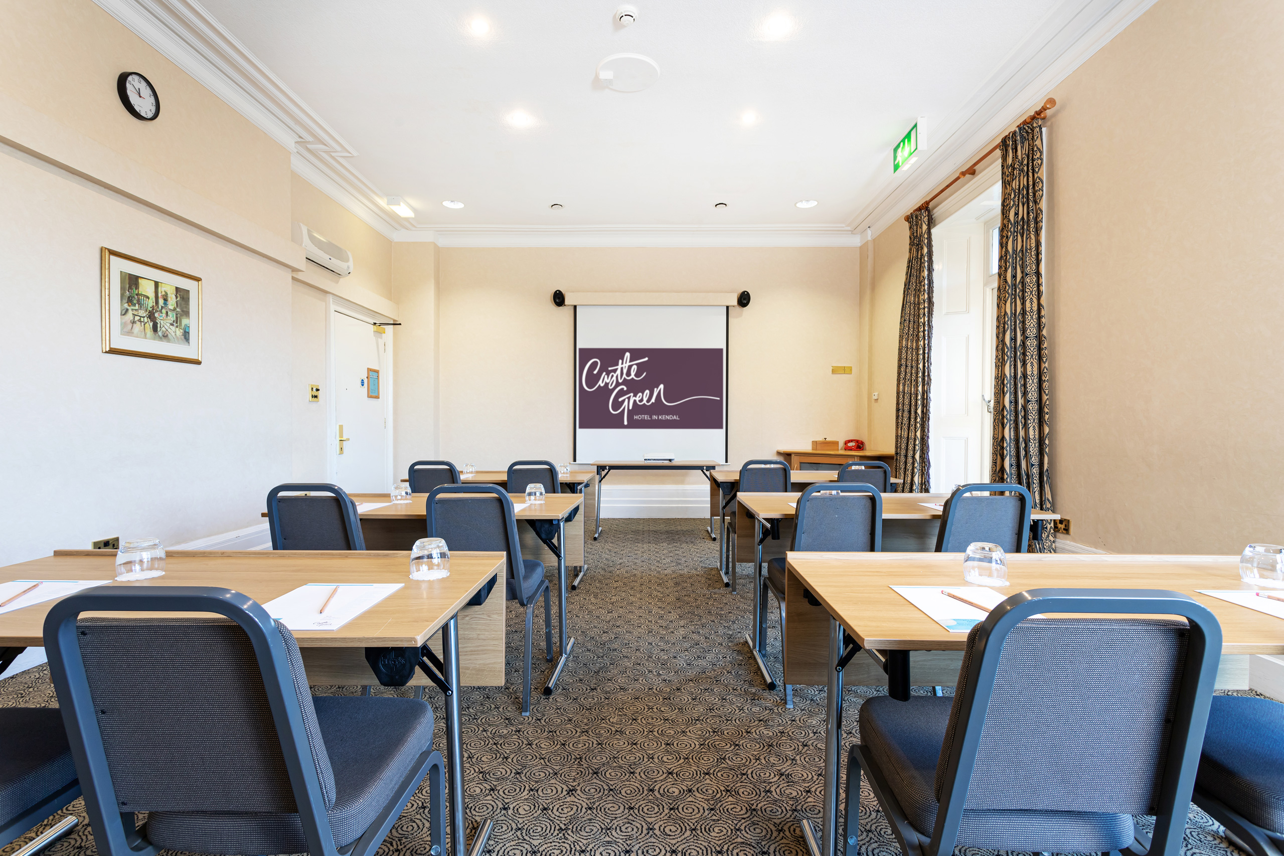 Garden Room at Castle Green Hotel, featuring a projector screen for meetings and workshops.