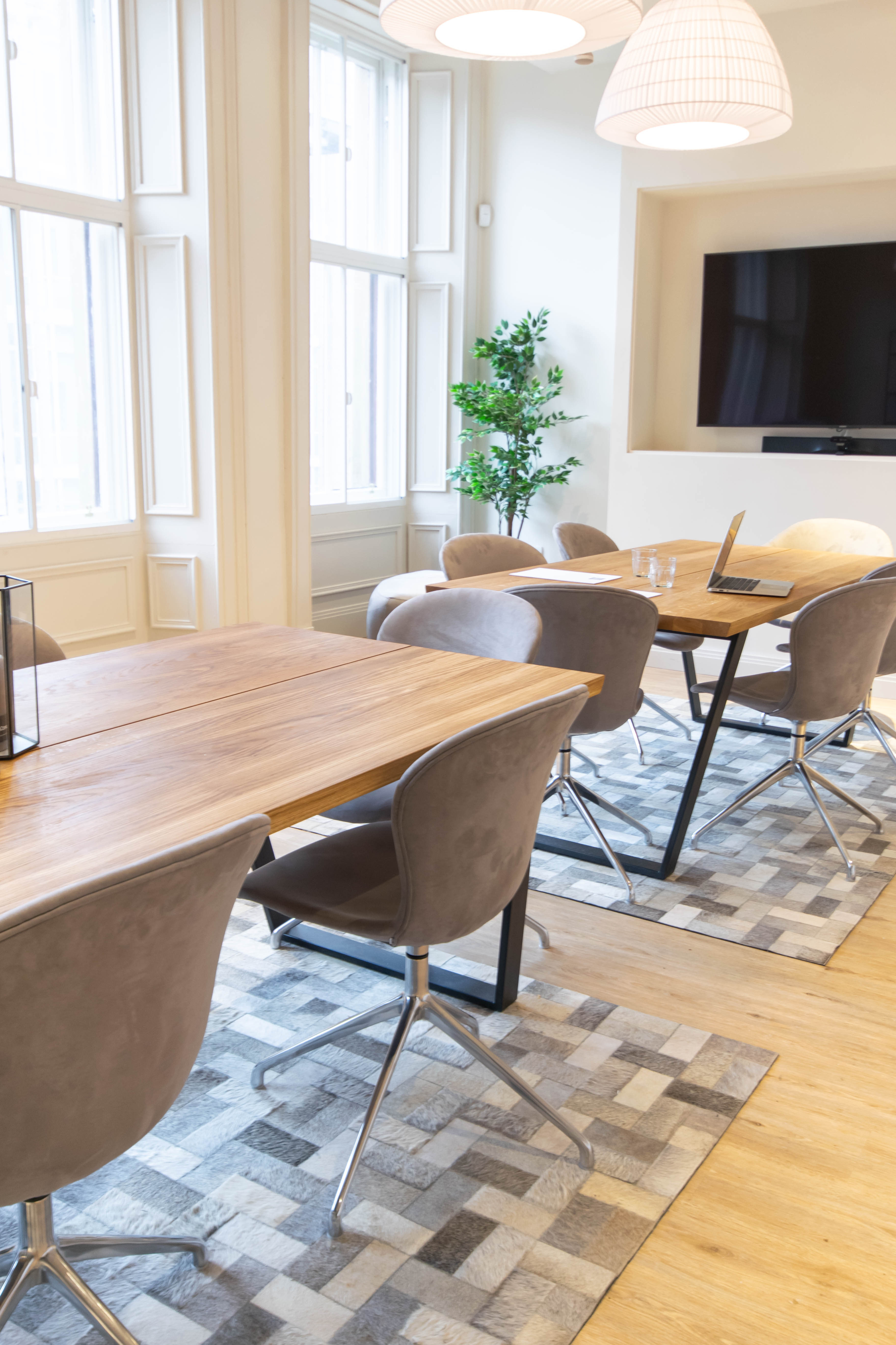 Modern meeting space at Mackintosh, featuring wooden tables for workshops and team meetings.