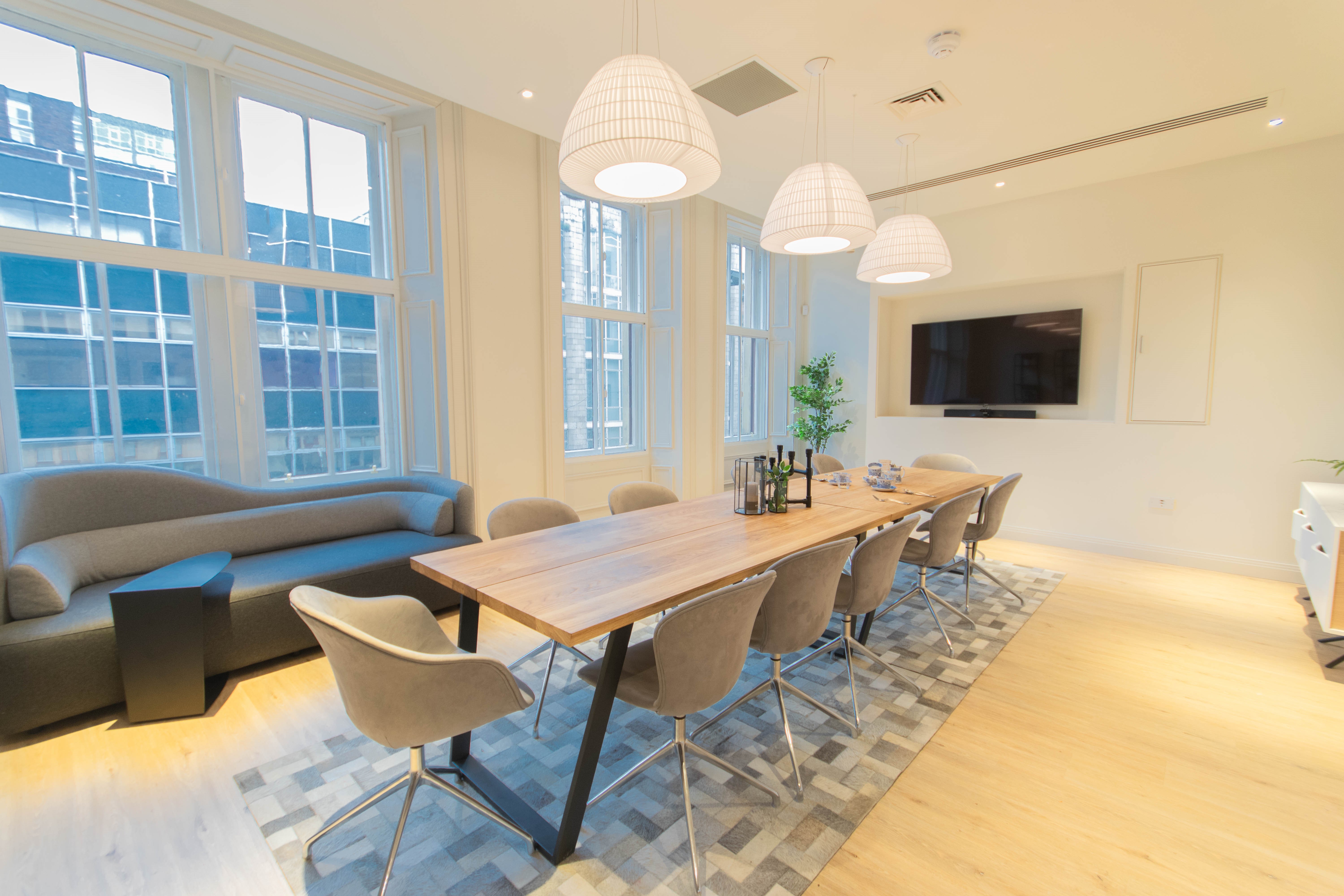 Modern meeting room at Mackintosh with large wooden table for collaborative events.