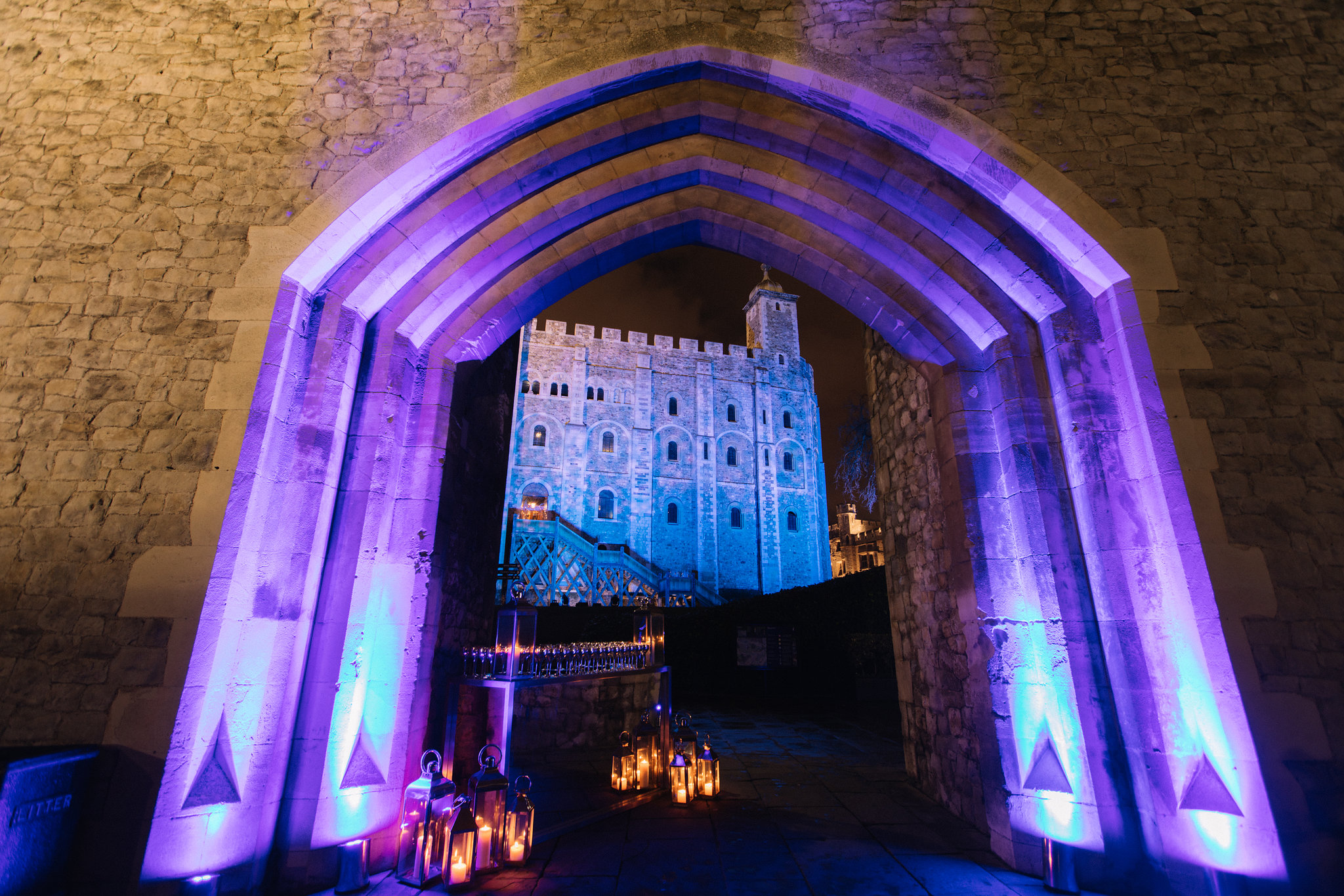 New Armouries entrance at Tower of London, stone archway with purple lighting for events.