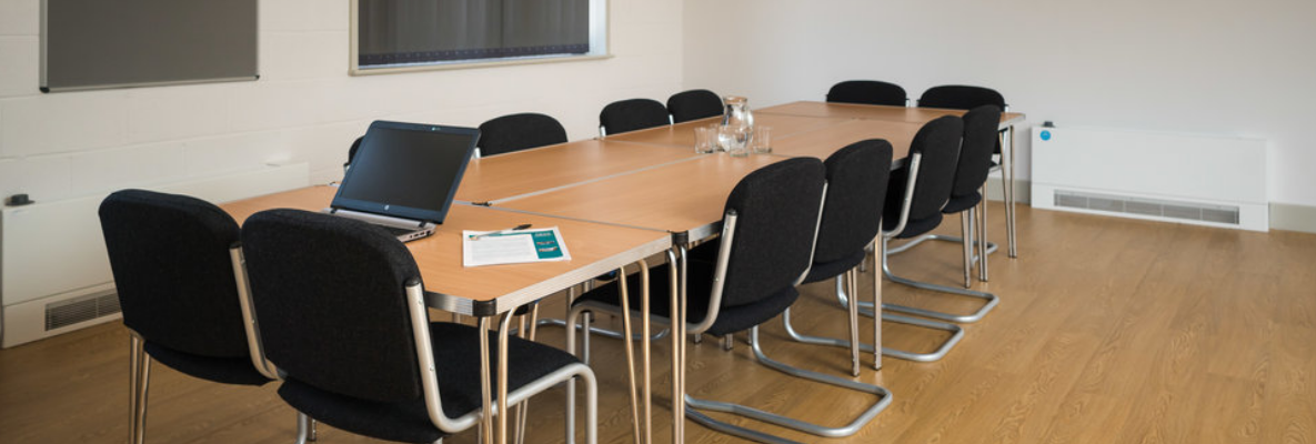 Milford Hall meeting room with long table, ideal for professional events and presentations.