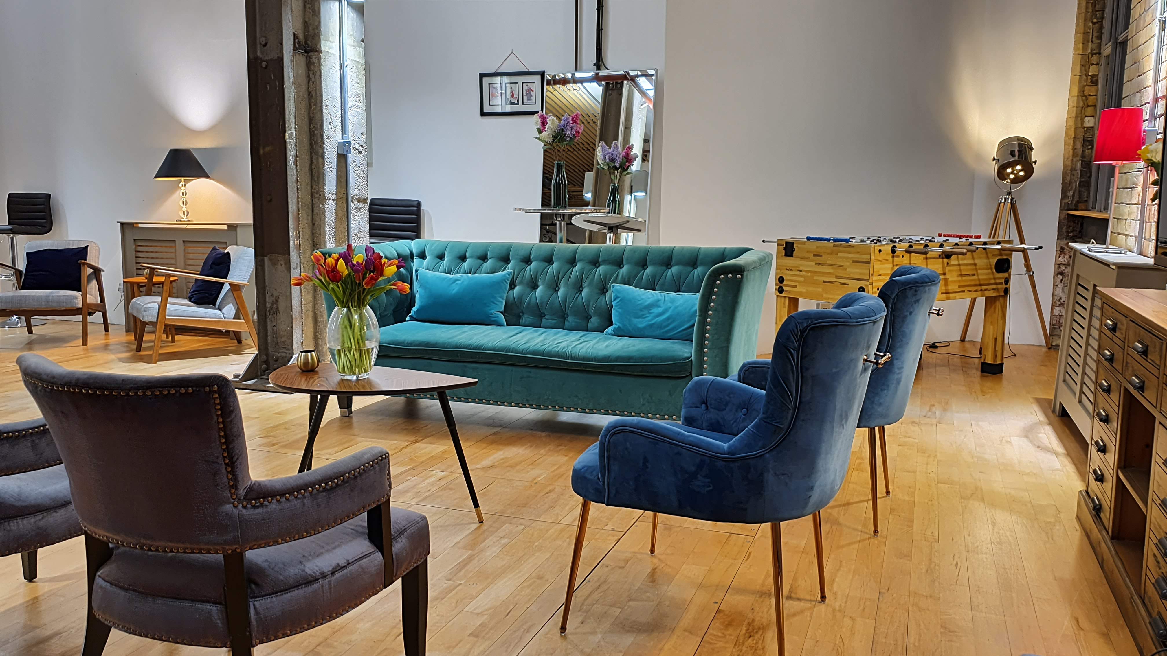Stylish meeting space at The New Yorker Gallery, featuring a teal sofa for gatherings.