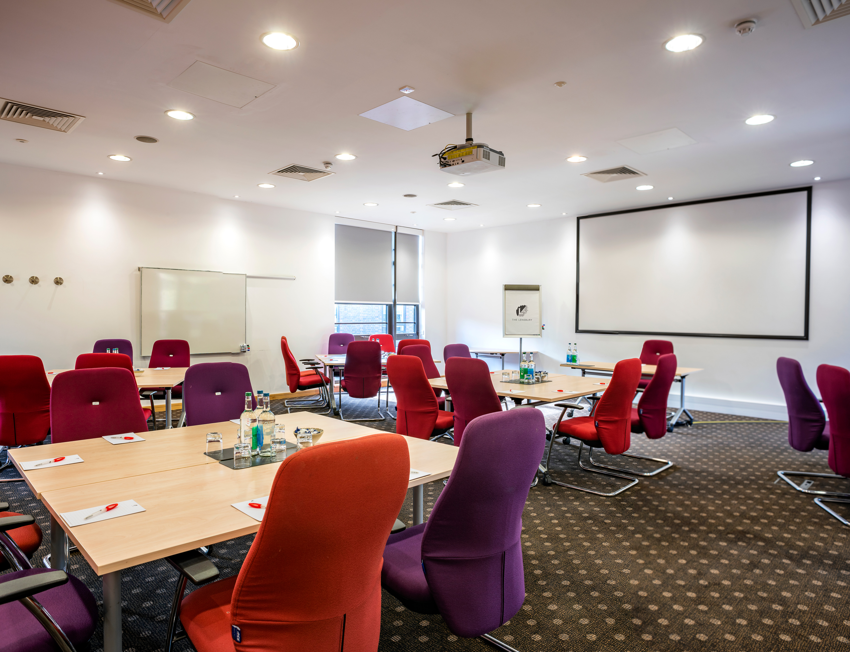 Modern meeting room at The Lensbury with vibrant seating for collaborative events.