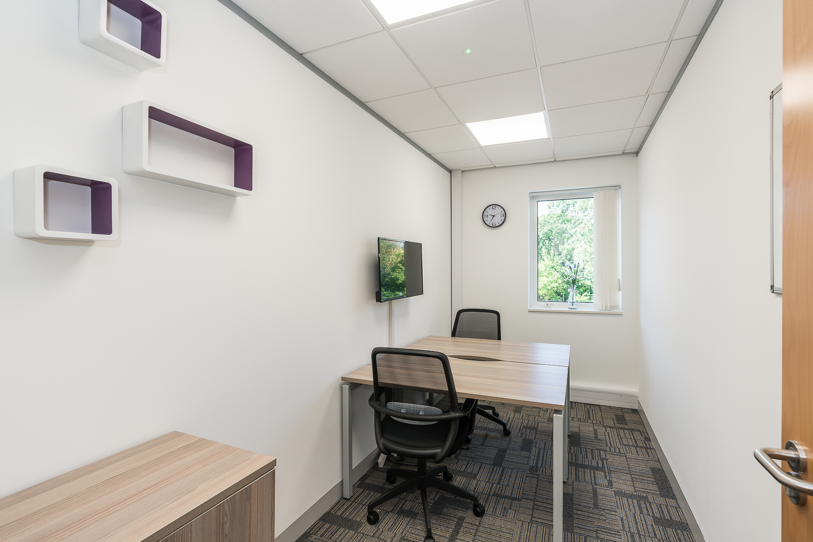 Purple Suite at UBC Warrington: modern meeting room with wall-mounted screen for presentations.