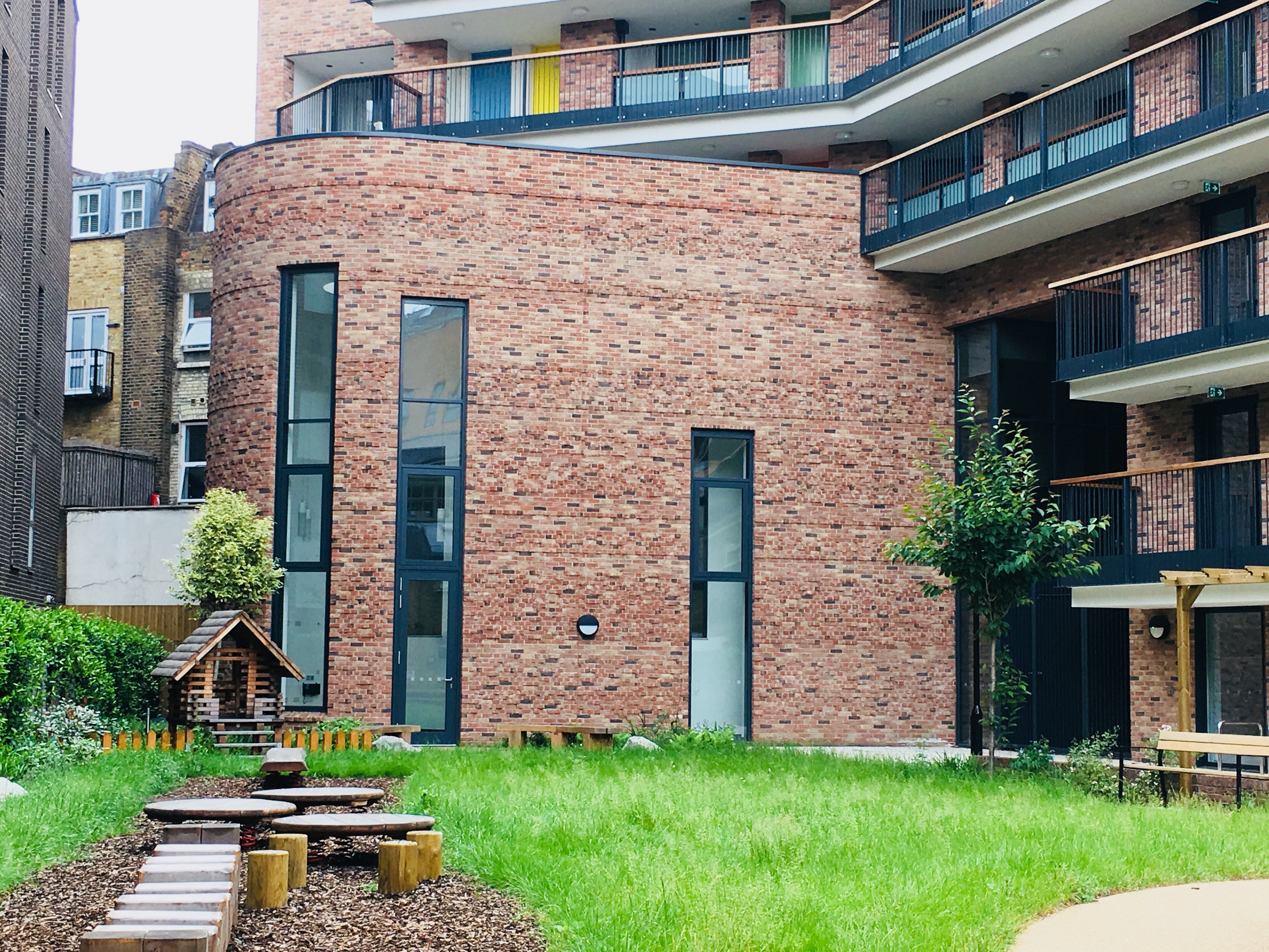 Modern brick-clad lecture hall with outdoor space for events and team-building activities.